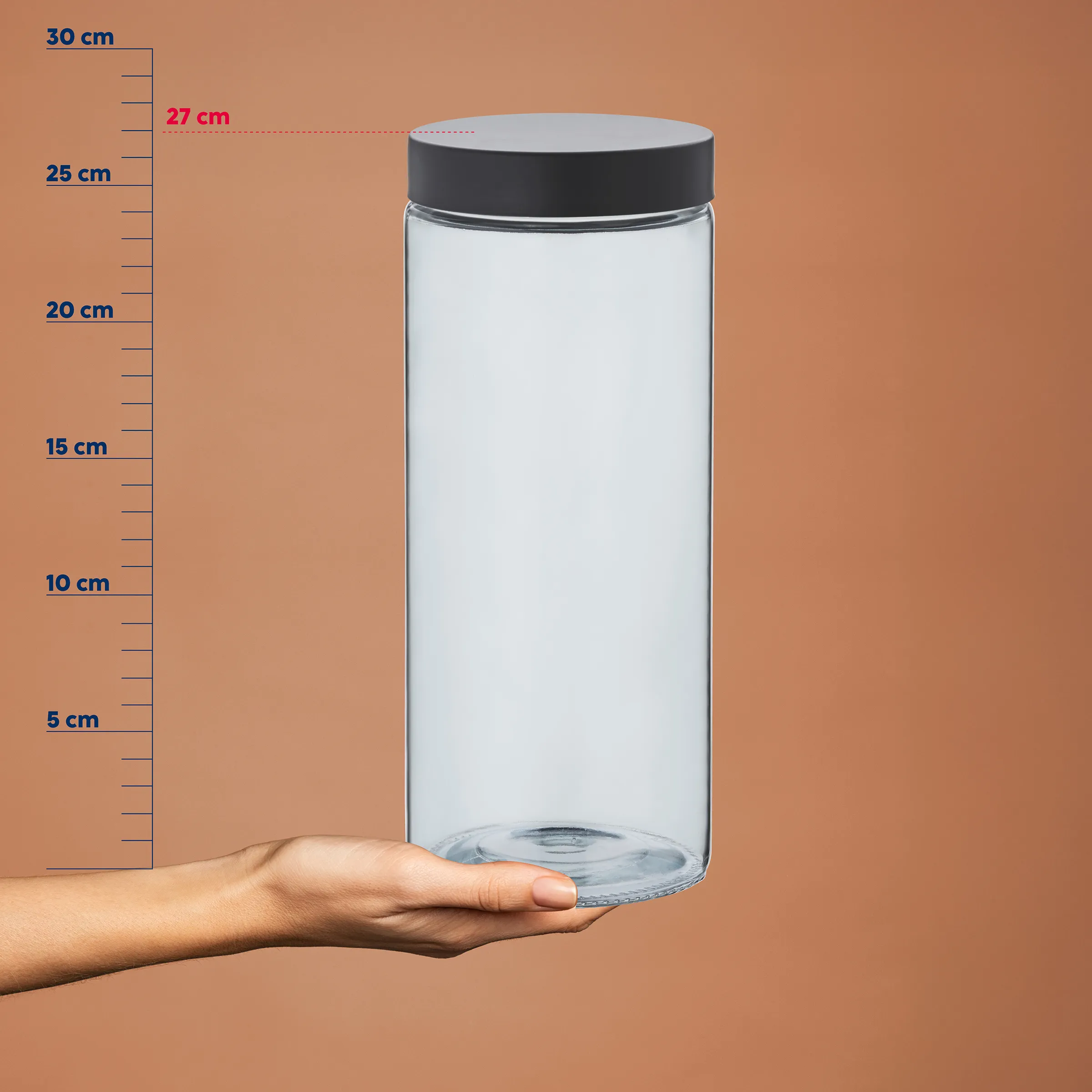 Transparenter Vorratsbehälter mit Deckel - 27cm Aufbewahrungsdose Transparenter Vorratsbehälter mit schwarzem Deckel, 27 cm hoch, von Hand gehalten vor Maßstab
