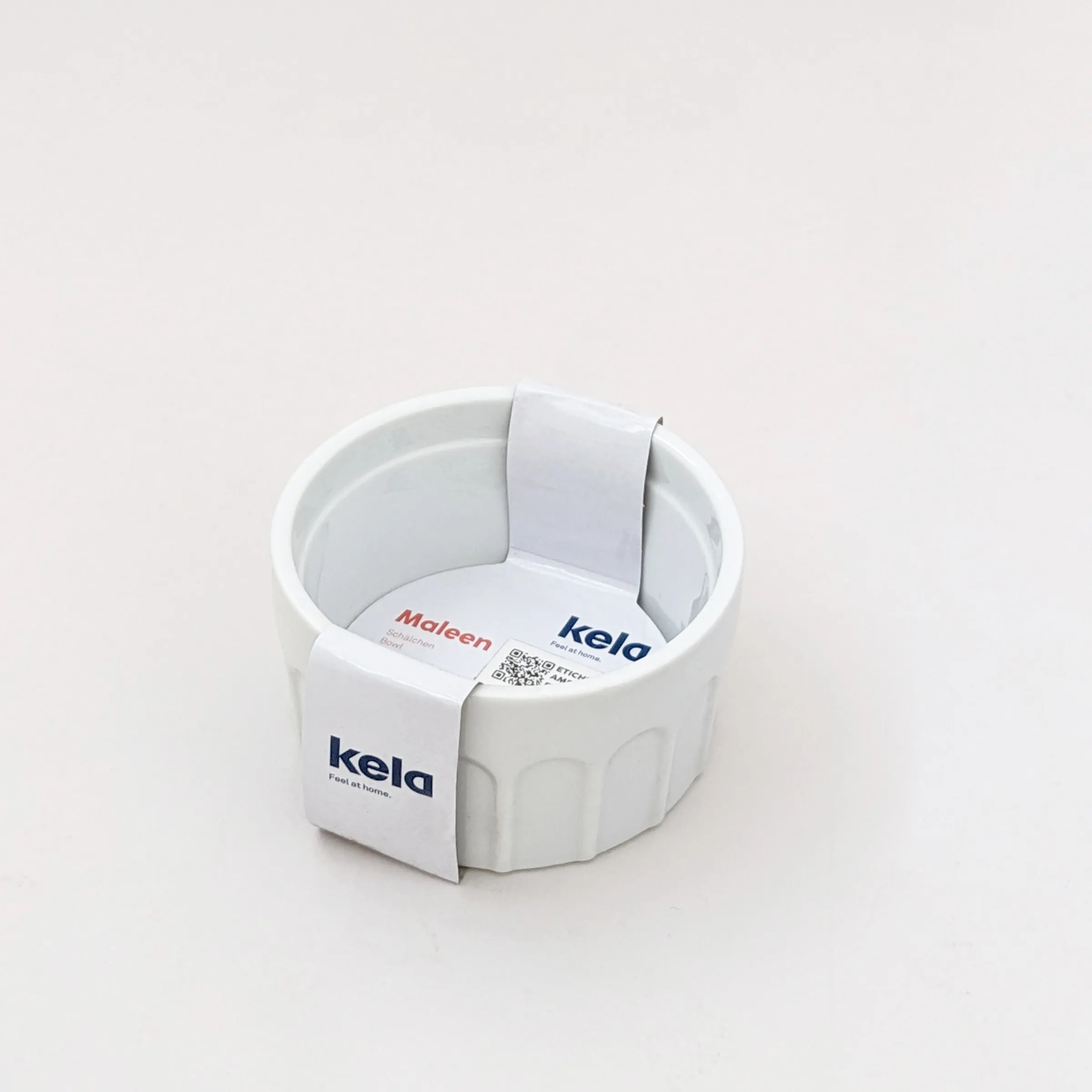 Kela Maleen Produktverpackung - Runde weiße Box mit Banderole Weiße runde Kela Maleen Produktverpackung mit Papierbanderole auf hellem Hintergrund
