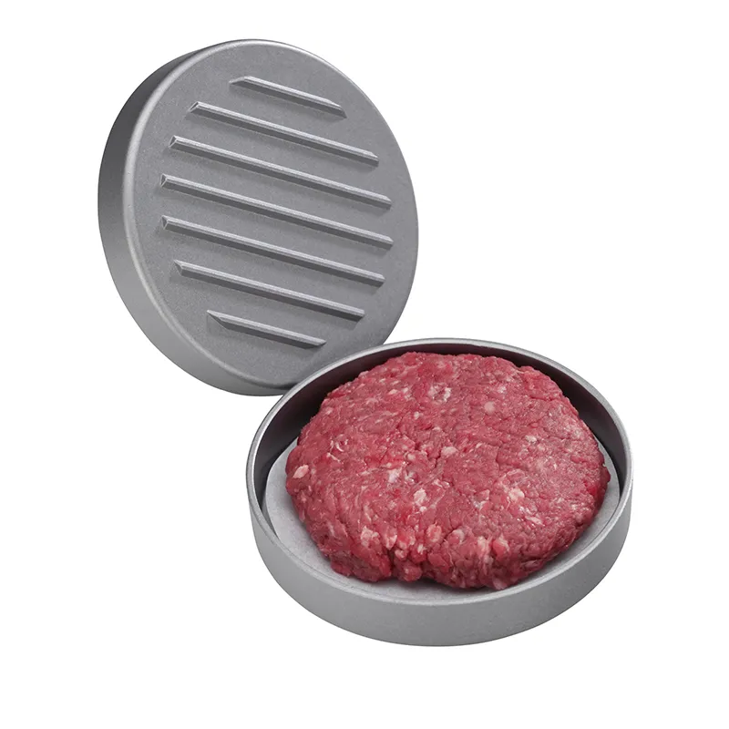 Aluminium Burgerpresse mit gerilltem Deckel und rohem Hackfleisch-Patty im Pressform