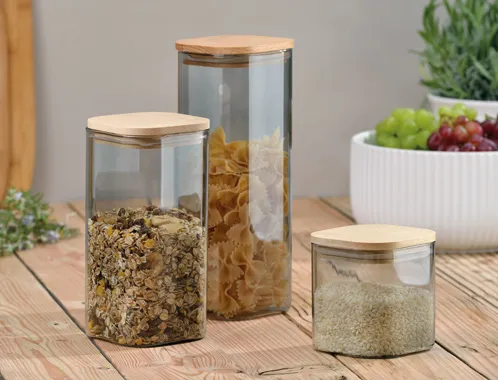 Vorratsdosen Glas mit Bambusdeckel - Luftdichte Aufbewahrung für Lebensmittel Vorratsdosen-Set aus Glas mit Bambusdeckel gefüllt mit Müsli, Pasta und Reis auf Holztisch in Küche