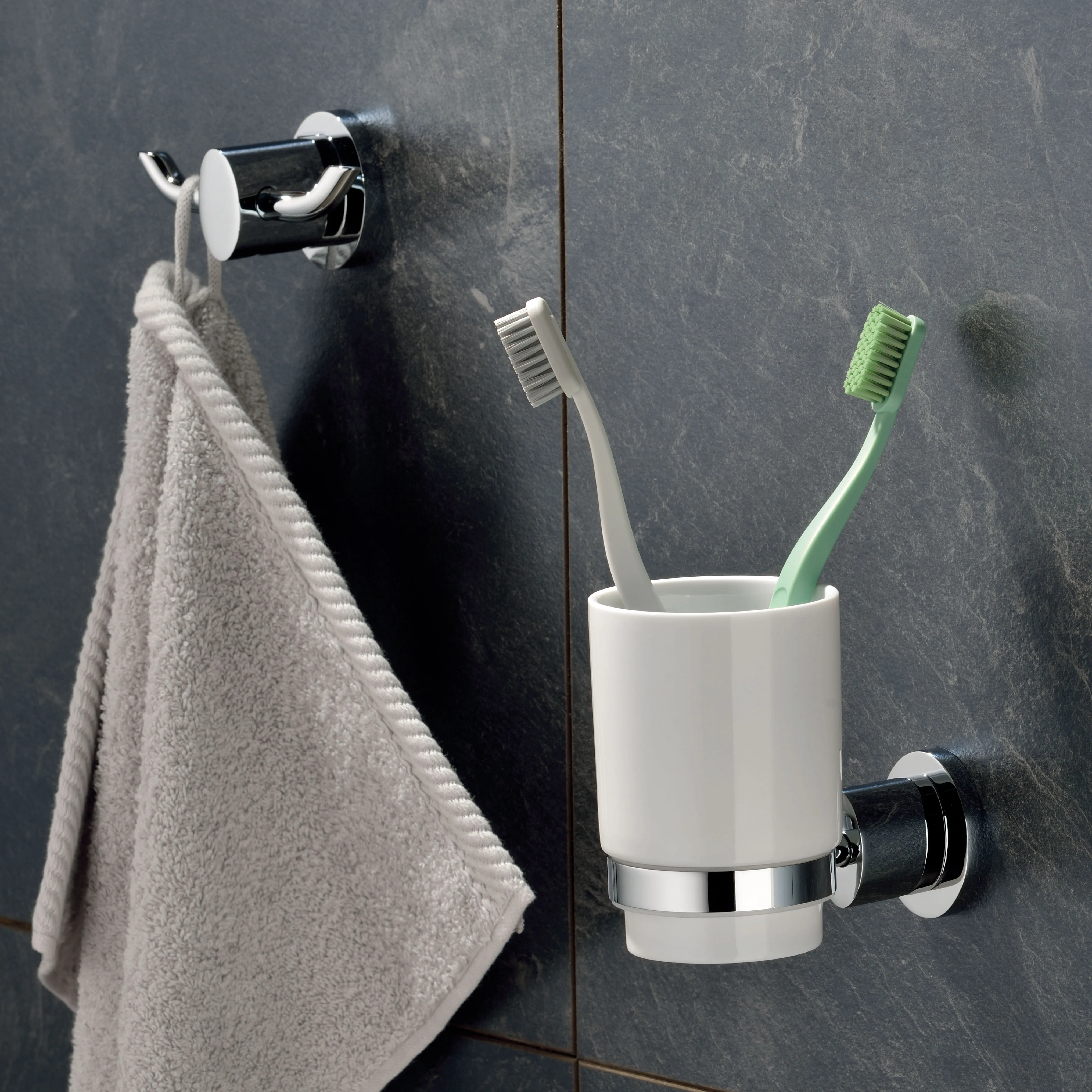 Badezimmer Accessoires Set Chrom - Handtuchhaken und Zahnbürstenhalter wandmontiert Modernes Badezimmer-Set mit Handtuchhaken und Zahnbürstenhalter aus Chrom an dunkelgrauer Fliesenwand
