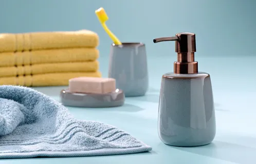 Badezimmer-Accessoires Set - Seifenspender und Handtücher in modernem Design Badezimmer-Set mit grauem Seifenspender, Zahnputzbecher mit gelber Bürste, Seife und Handtüchern