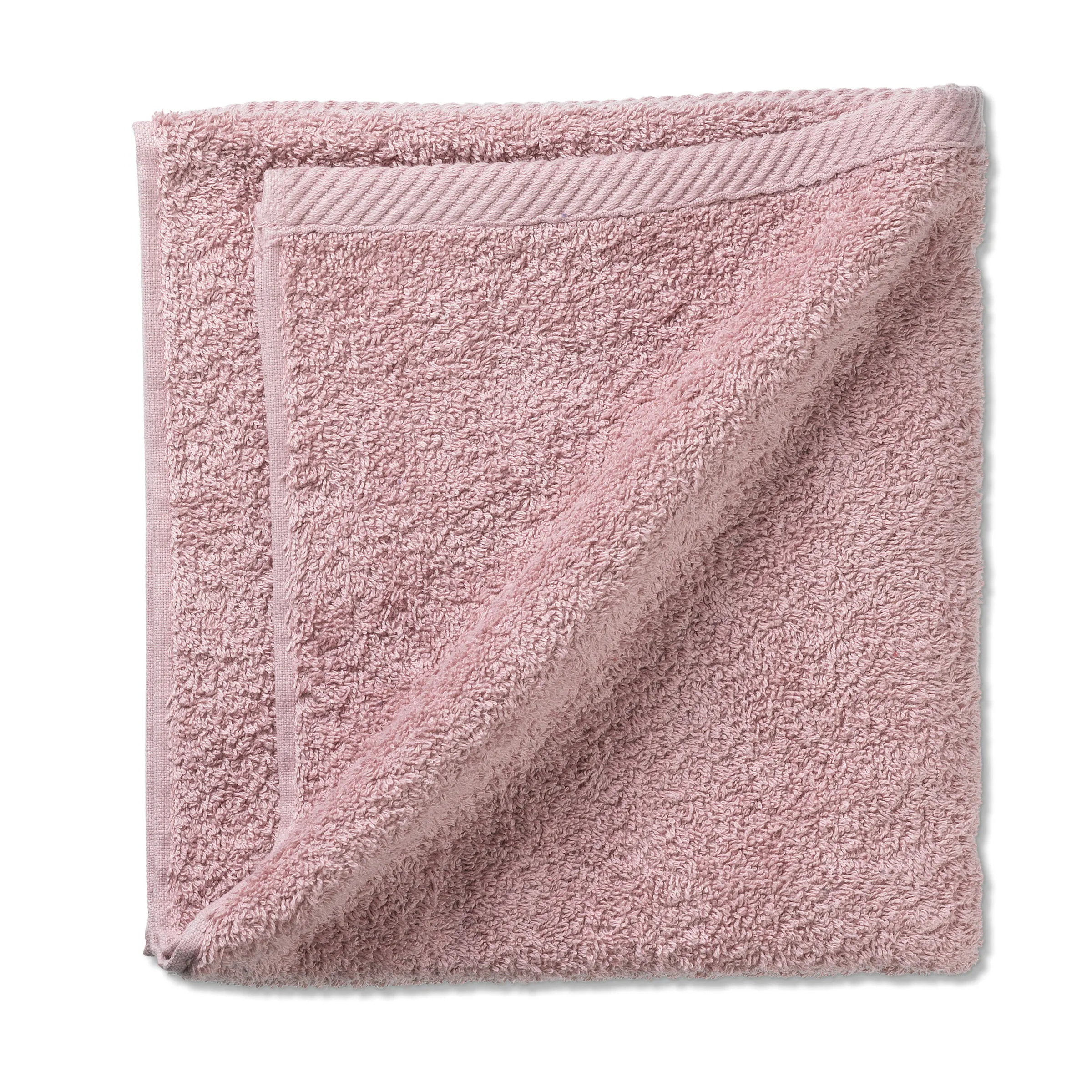 Weiches Frotteehandtuch rosa Baumwolle Hellrosa Frotteehandtuch mit strukturierter Oberfläche und gewebtem Rand, zusammengerollt.