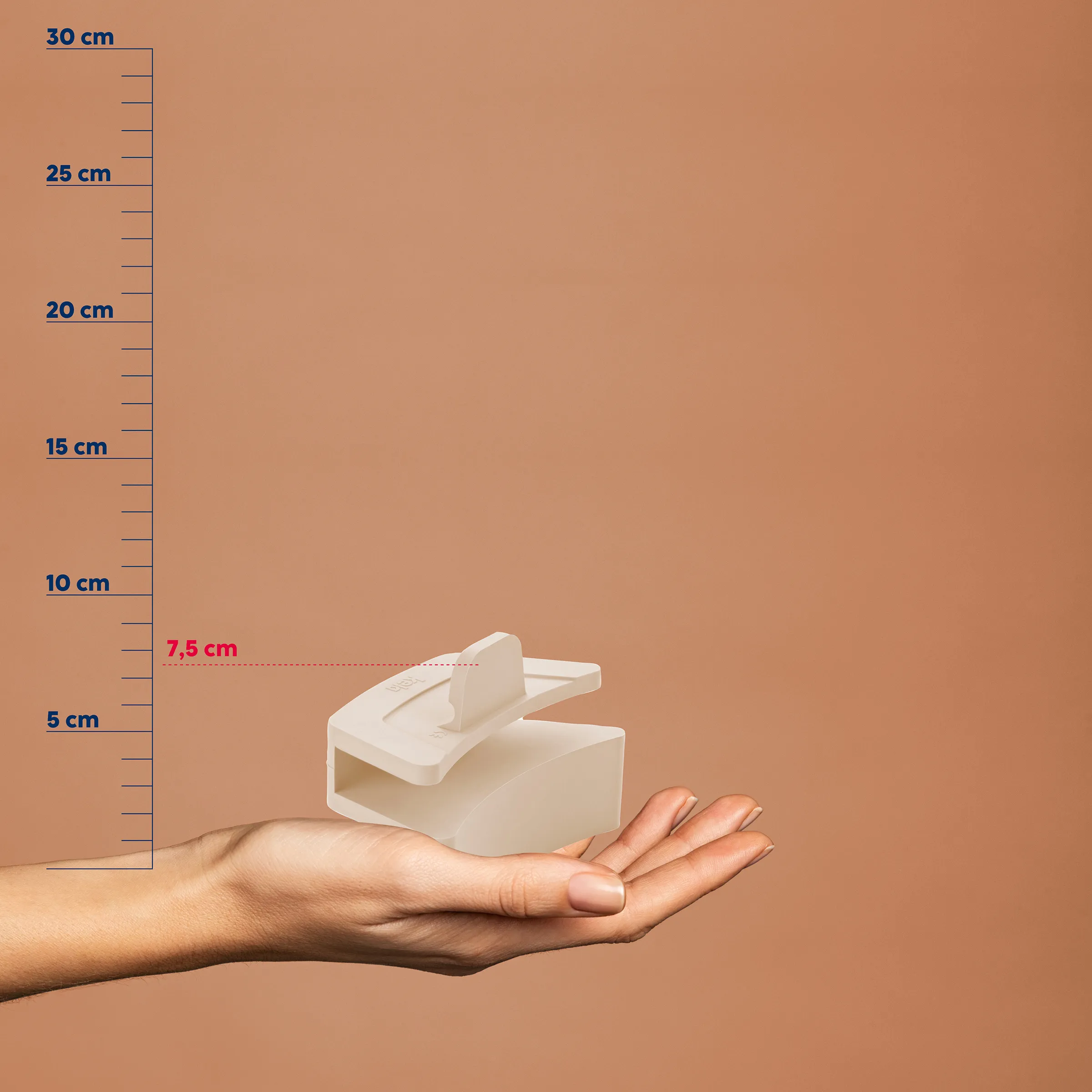 Tischabroller - Kompaktes Klebeband Dispenser Weiße Tischabroller in einer offenen Hand vor braunem Hintergrund mit Größenvergleich-Skala