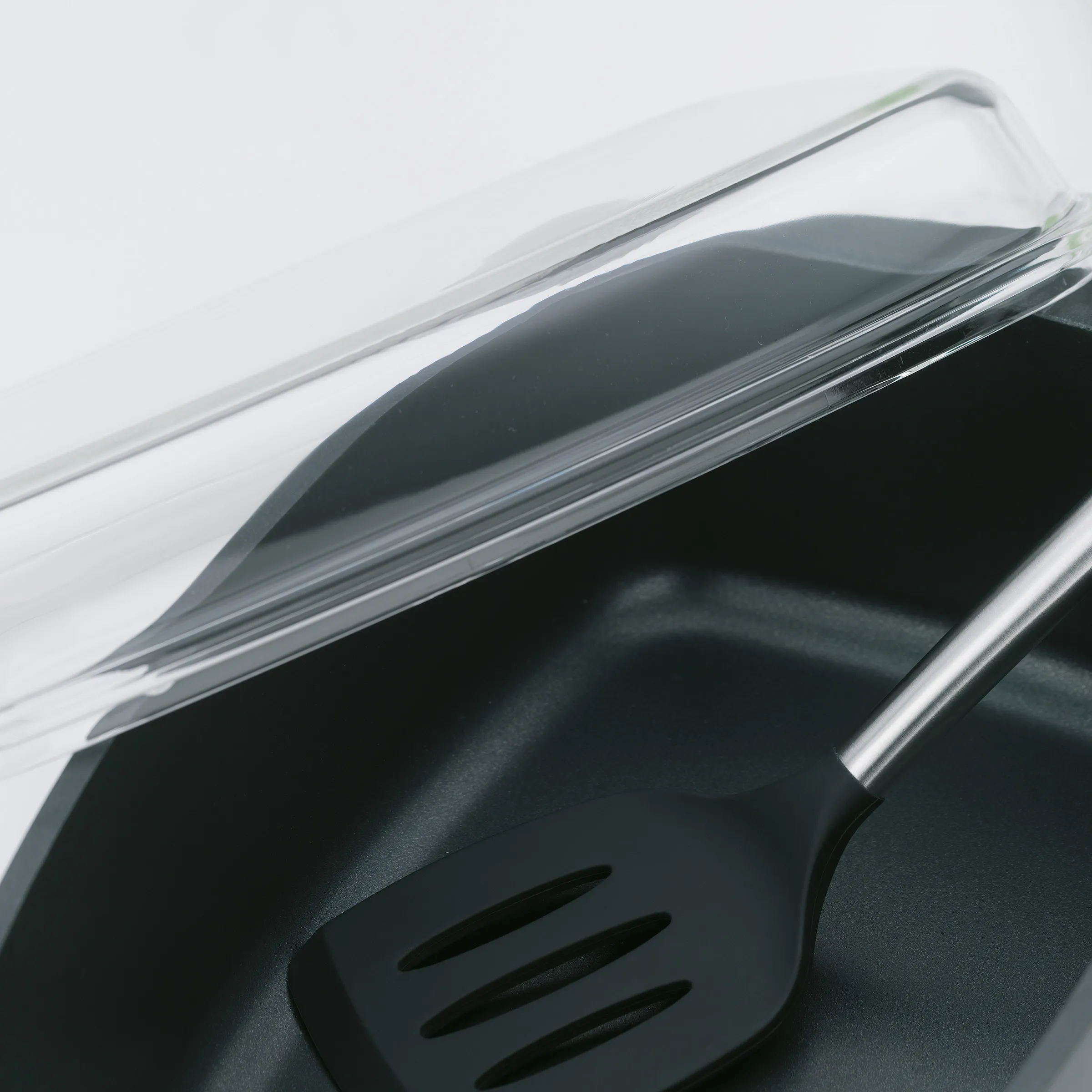 Pfanne mit Glasdeckel und Dampfaustritt - Antihaft-Kochgeschirr Detail Glasdeckel auf schwarzem Pfannenkörper mit Dampfaustrittsöffnung, Nahaufnahme der ergonomischen Form