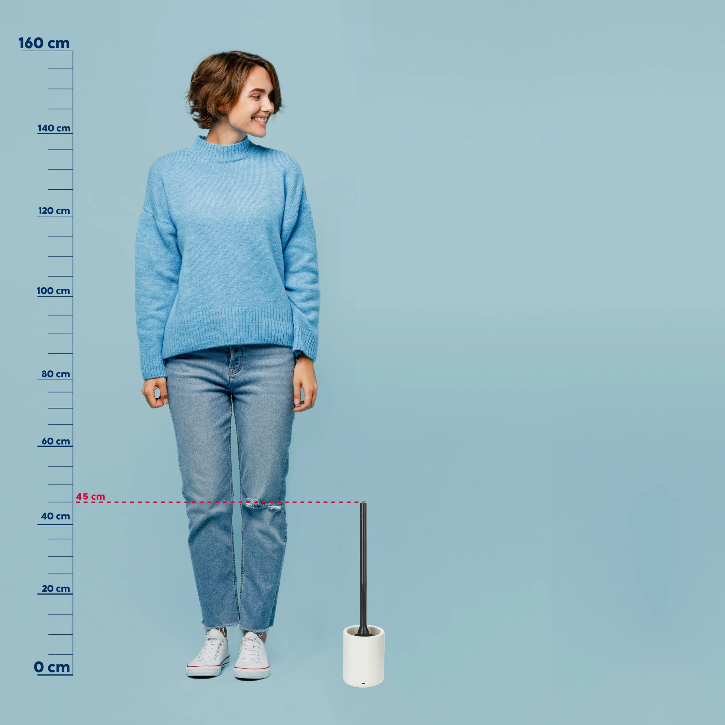 Rollkragenpullover Damen hellblau - Größenvergleich Frau mit braunem Bob trägt hellblauen Rollkragenpullover und Jeans, steht vor blauem Hintergrund neben Messstab