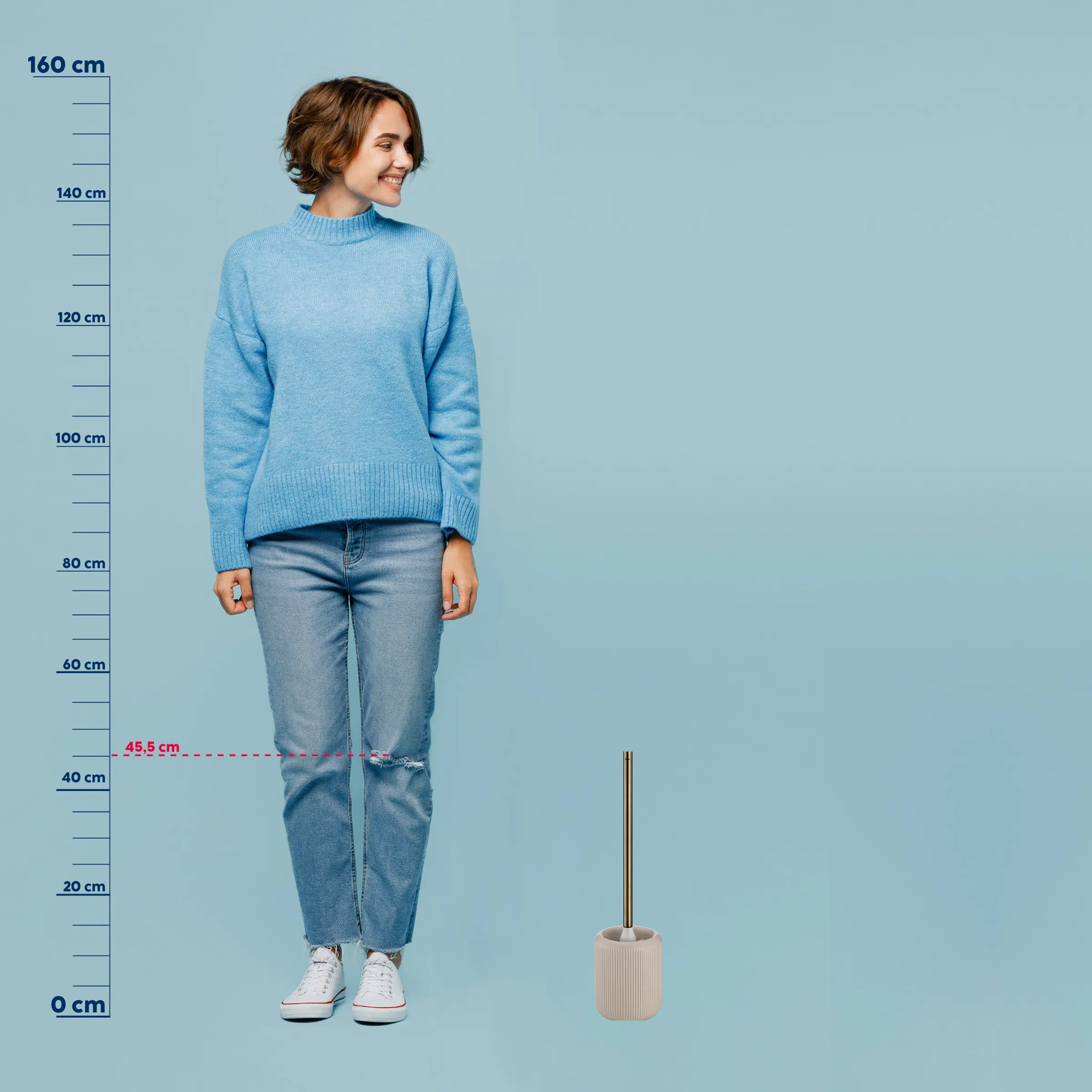 Größenmessstab mit Frau im blauen Pullover - Größenvergleich Produktfoto Junge Frau in hellblauem Strickpullover und zerrissenen Jeans posiert vor Größenmessstab
