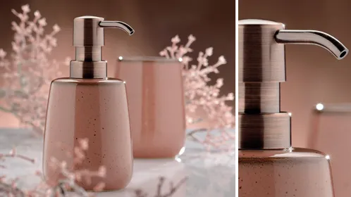 Badezimmer-Accessoires Set mit rosafarbenem Seifenspender, Zahnbürstenhalter und Deko-Elementen auf Marmor