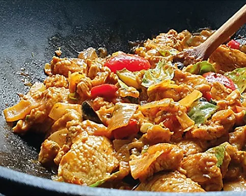 Asian Chicken Stir-Fry with Vegetables and Sesame in Wok Asian chicken stir-fry with bell peppers, sesame seeds, and bamboo shoots cooked in wok