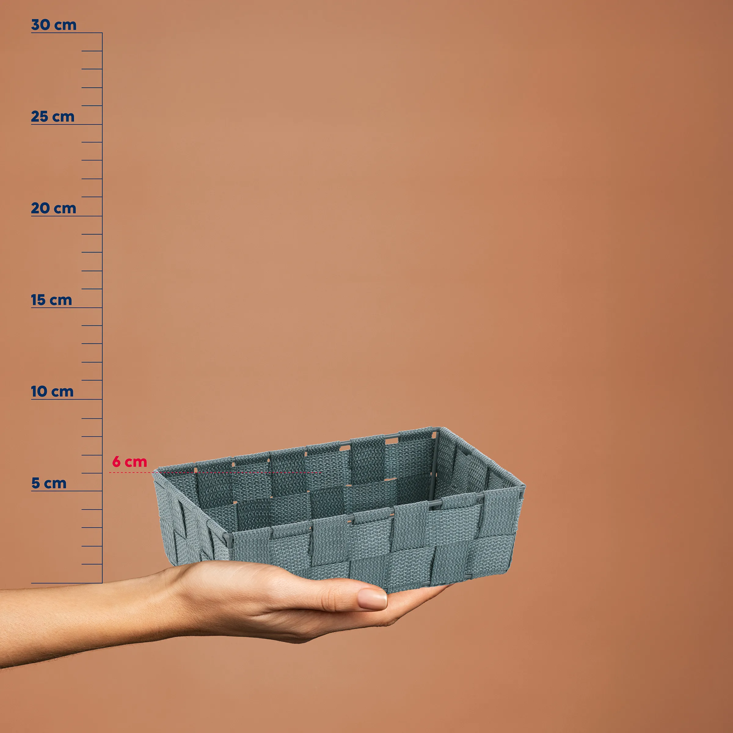 Grauer Kunststoff-Organizer mit Fächern in einer Hand, neben einer Messskala von 5 bis 30 cm, Höhe etwa 6 cm