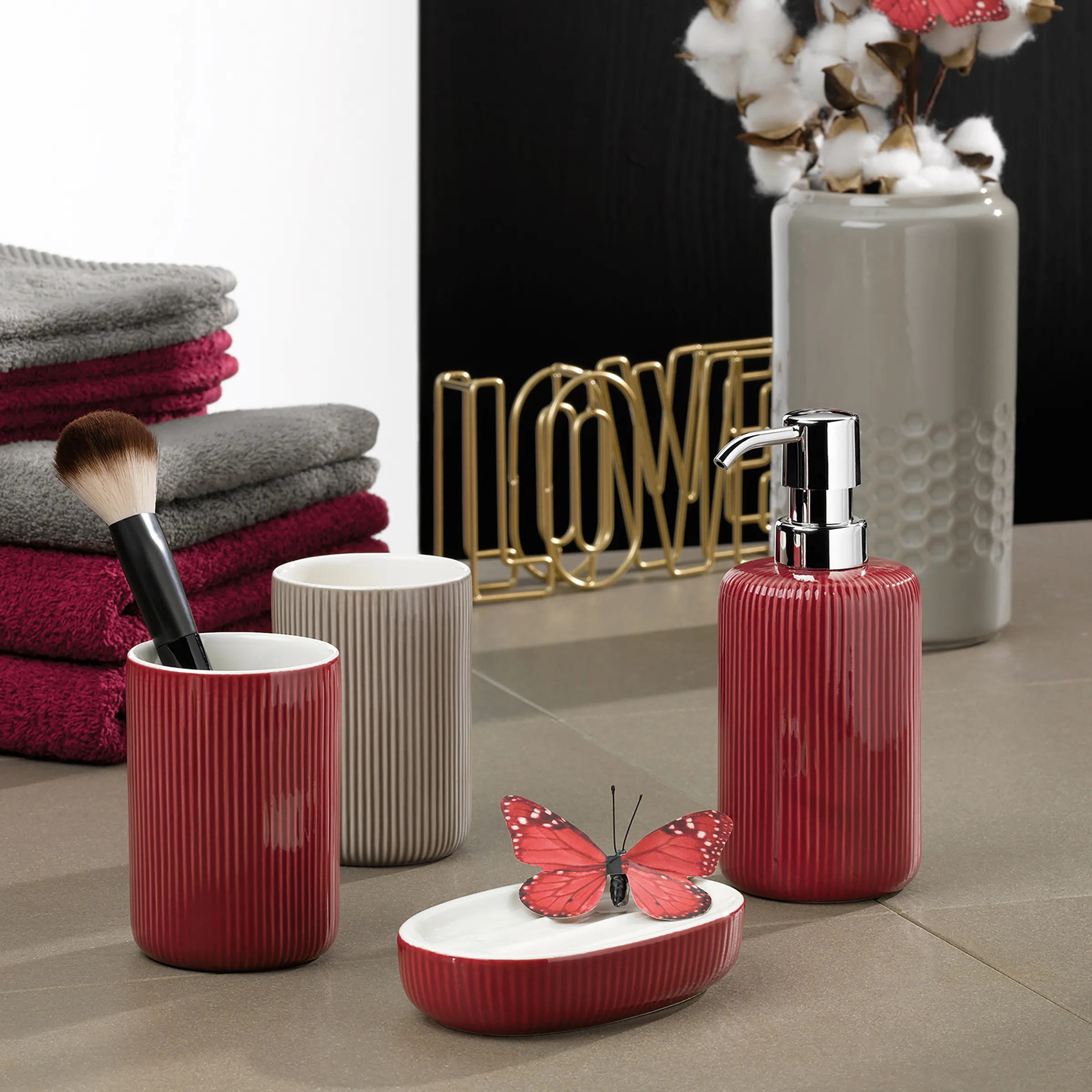 Badezimmer-Accessoires Set rot grau Luxus Luxus-Badezimmer-Set mit roten Gefäßen, grauen Handtüchern, Schmetterlingsseife und Blumenvase auf grauem Marmor