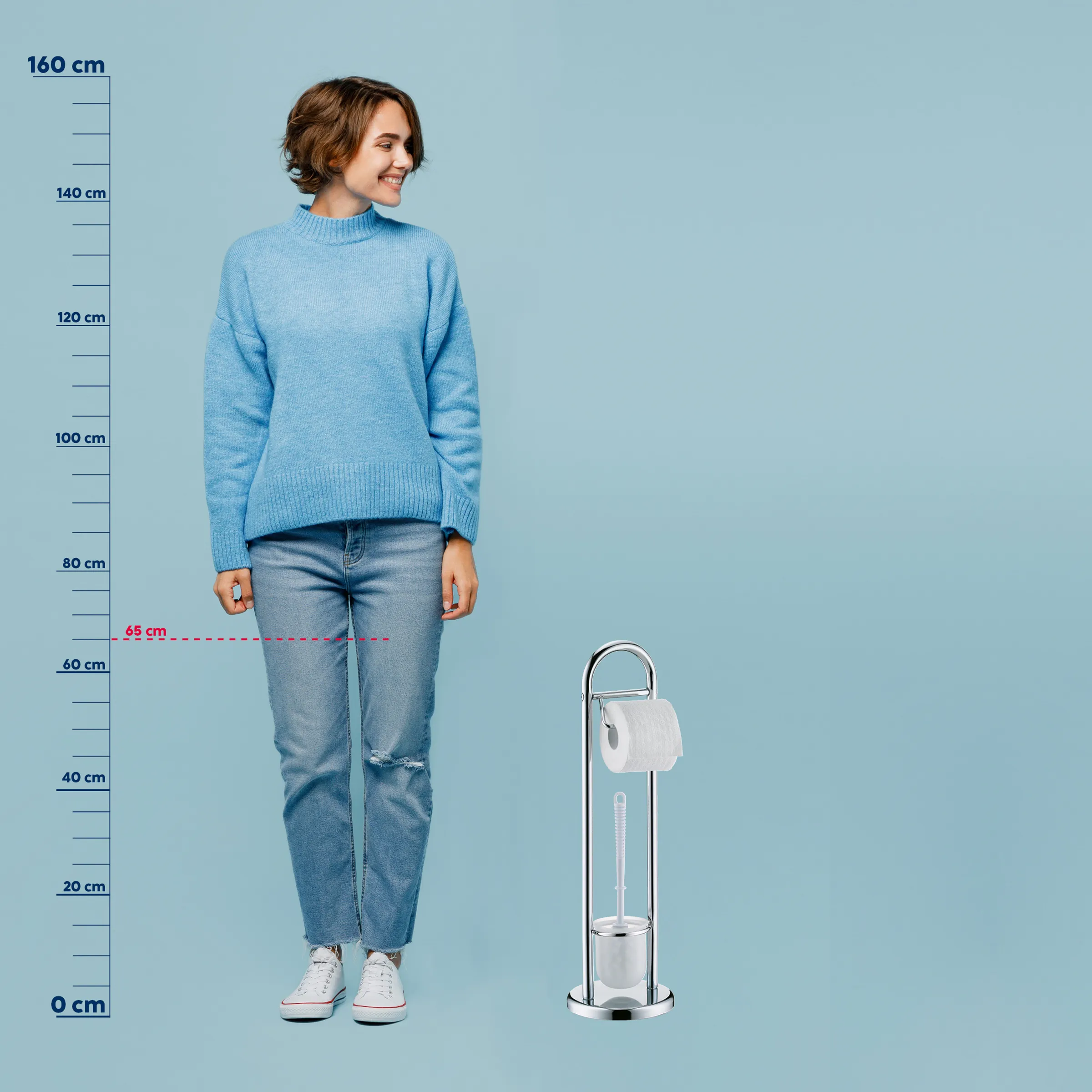 Toilettenpapierhalter mit Maßstab und Größenvergleich Frau mit blauem Pullover und Jeans steht neben einem Toilettenpapierhalter mit Maßstab zur Größenvergleich