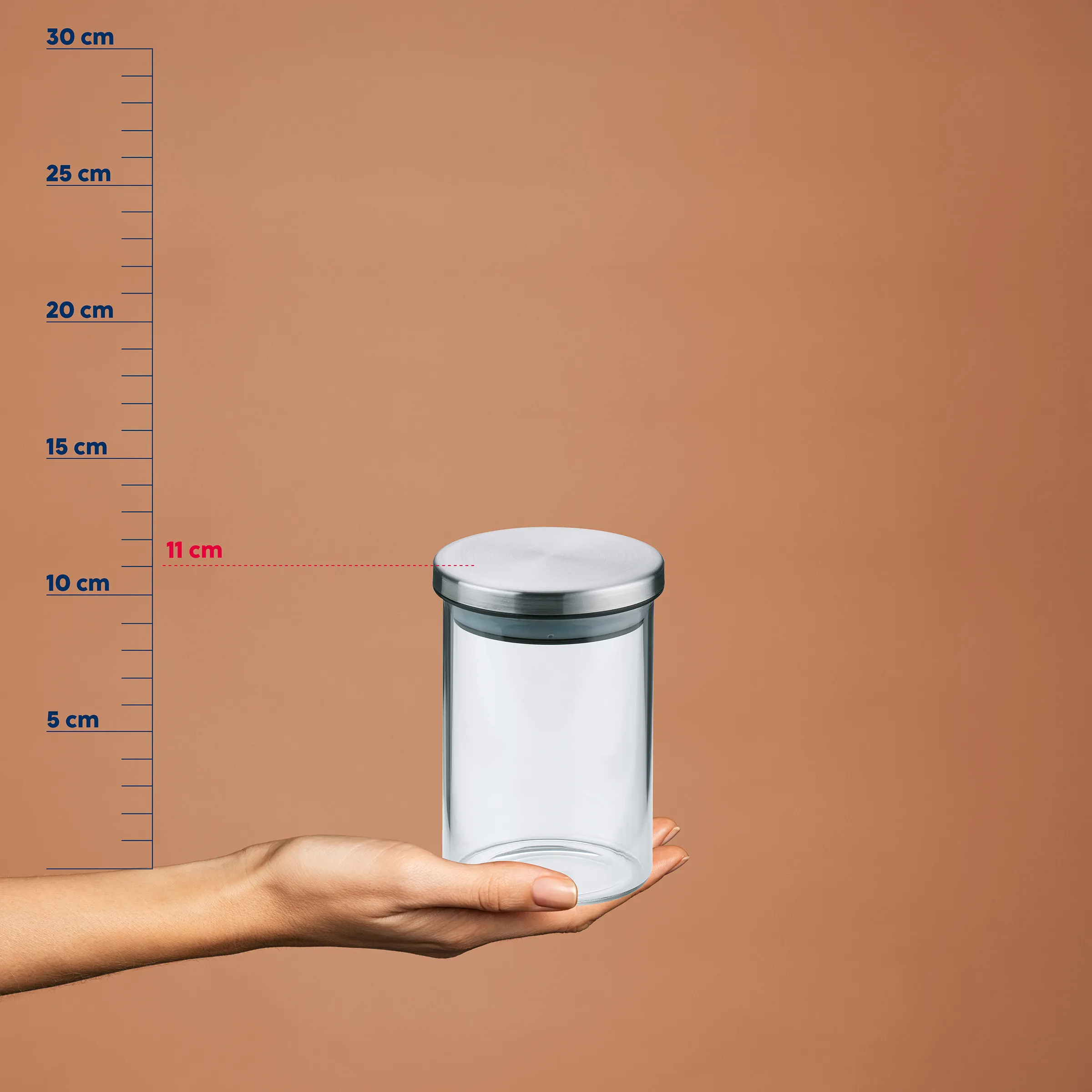 Vorratsglas mit Metalldeckel 11 cm - Transparenter Aufbewahrungsbehälter Hand hält durchsichtiges Vorratsglas mit Metalldeckel vor Maßstab, Höhe 11 cm