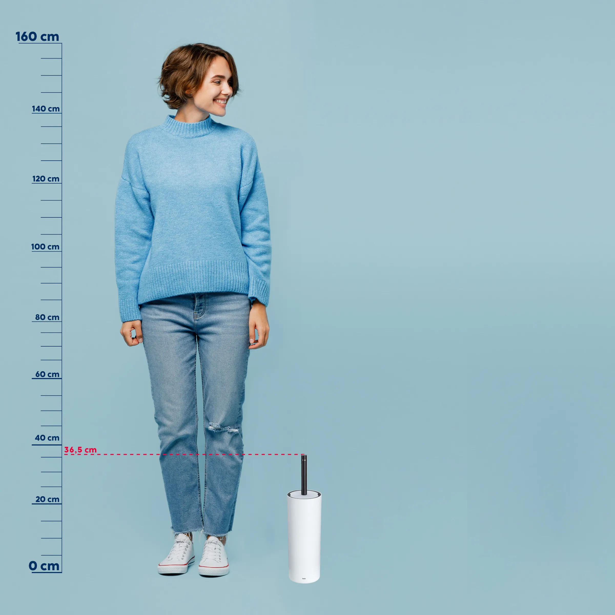 Papiertuchhalter Größenvergleich - Praktisches Küchenprodukt Frau in hellblauem Rollkragen-Pullover und zerrissener Jeans mit Größenmaßstab, Papiertuchhalter zeigt 36,5 cm Höhe