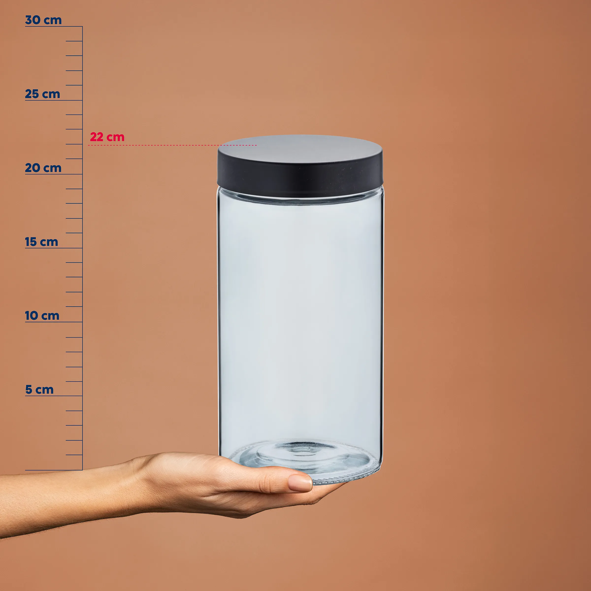 Kunststoffbox mit Deckel - 22 cm Durchmesser Lagerbehälter Transparente Kunststoffbox mit schwarzem Deckel, Durchmesser 22 cm, auf einer Hand vor einer Messskala