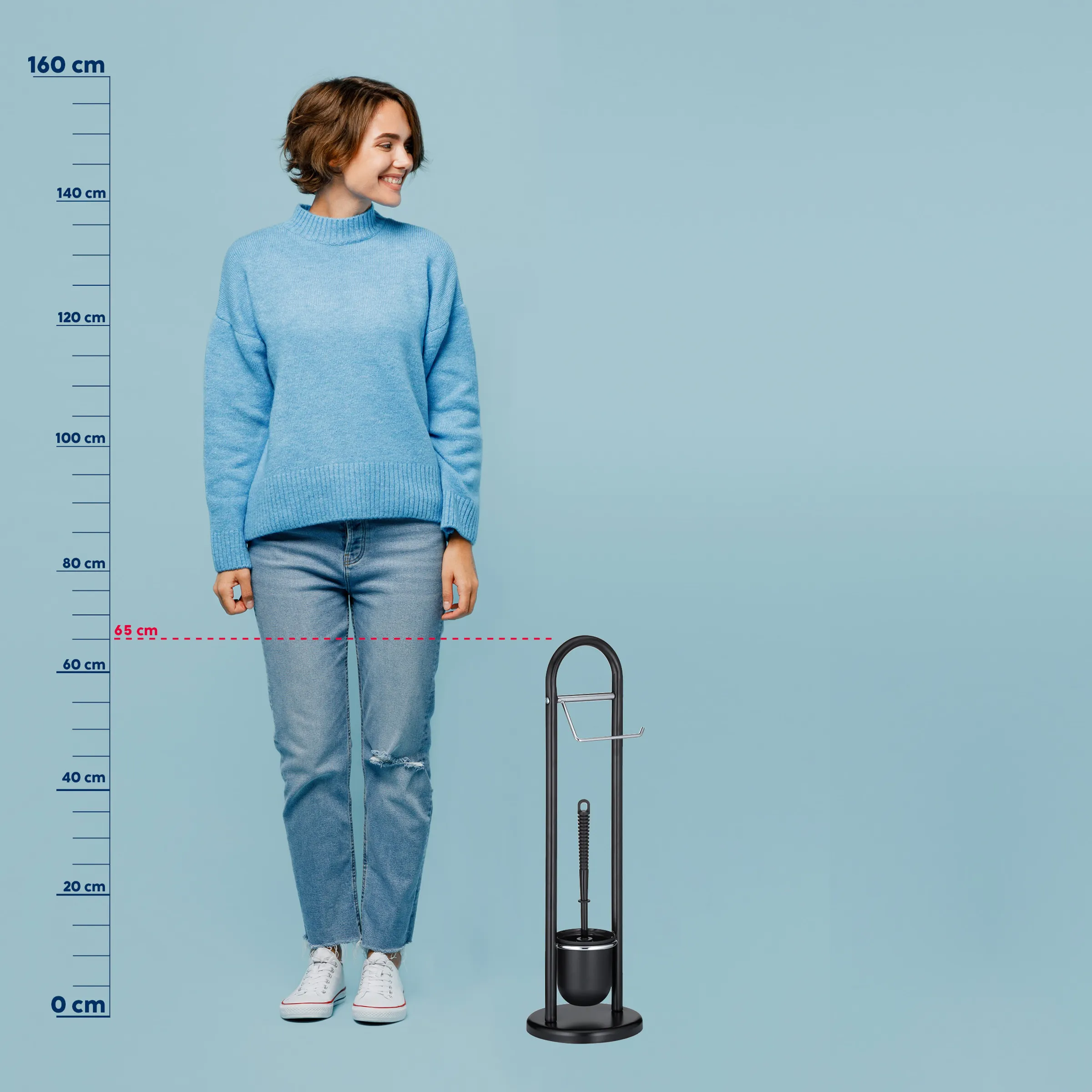 Schirmständer klein kompakt Größenvergleich Frau in blauem Pullover und Jeans neben schwarzem Schirmständer mit Größenvergleich bis 65 cm Höhe