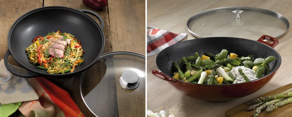 Wok-Pfanne mit Glasdeckel und Antihaftbeschichtung für asiatische Gerichte und Gemüse Wok-Pfanne mit Deckel und asiatischen Nudeln, daneben rote Pfanne mit gedünstetem Gemüse auf Holzuntergrund