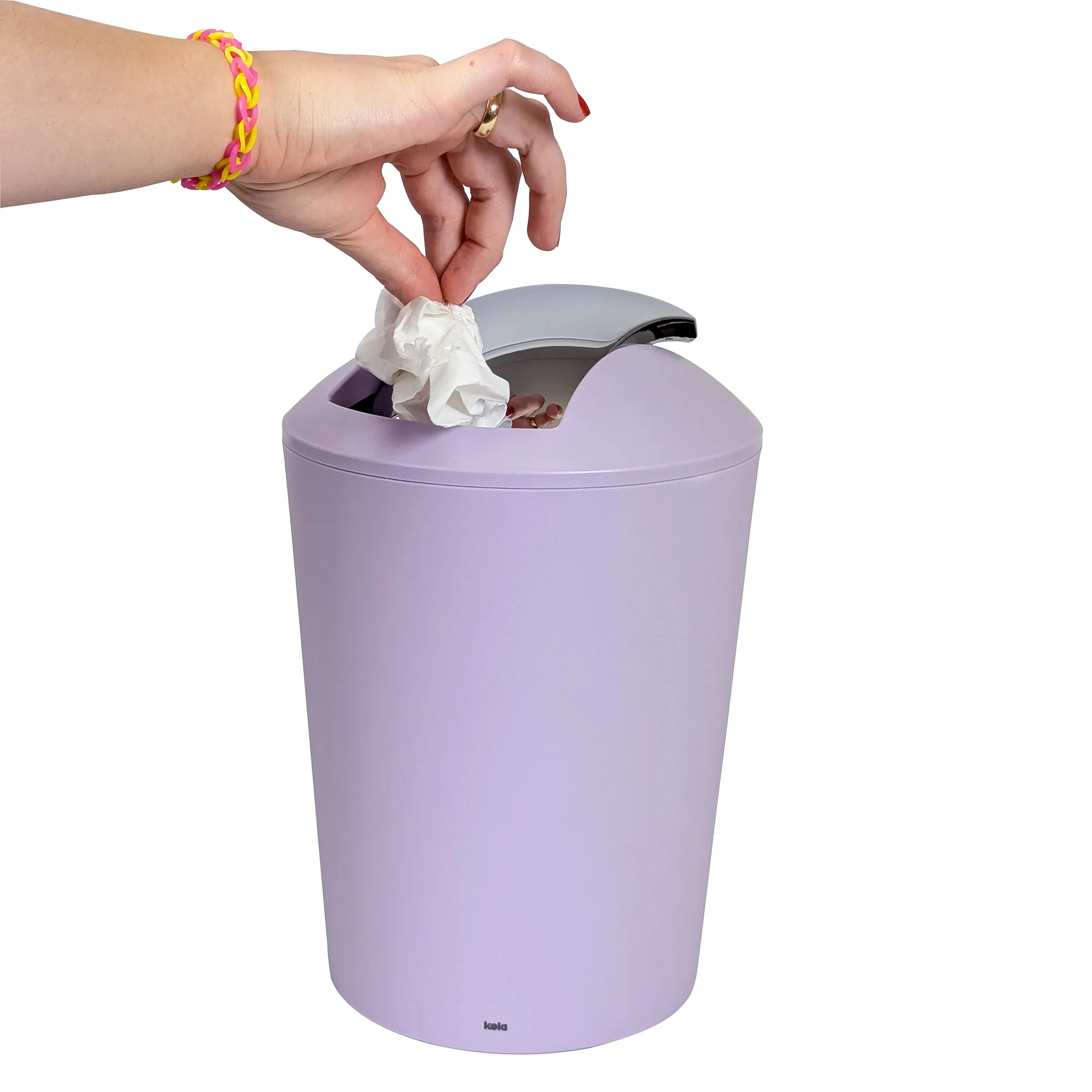 Lila Mülleimer mit Schwingdeckel – Hand entsorgt Papiertaschentuch Hand wirft zerknülltes Papier in lila Mülleimer mit Schwingdeckel