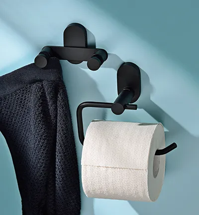 Schwarze Handtuchhalter an blauer Wand mit dunklem Handtuch und Toilettenpapierrolle