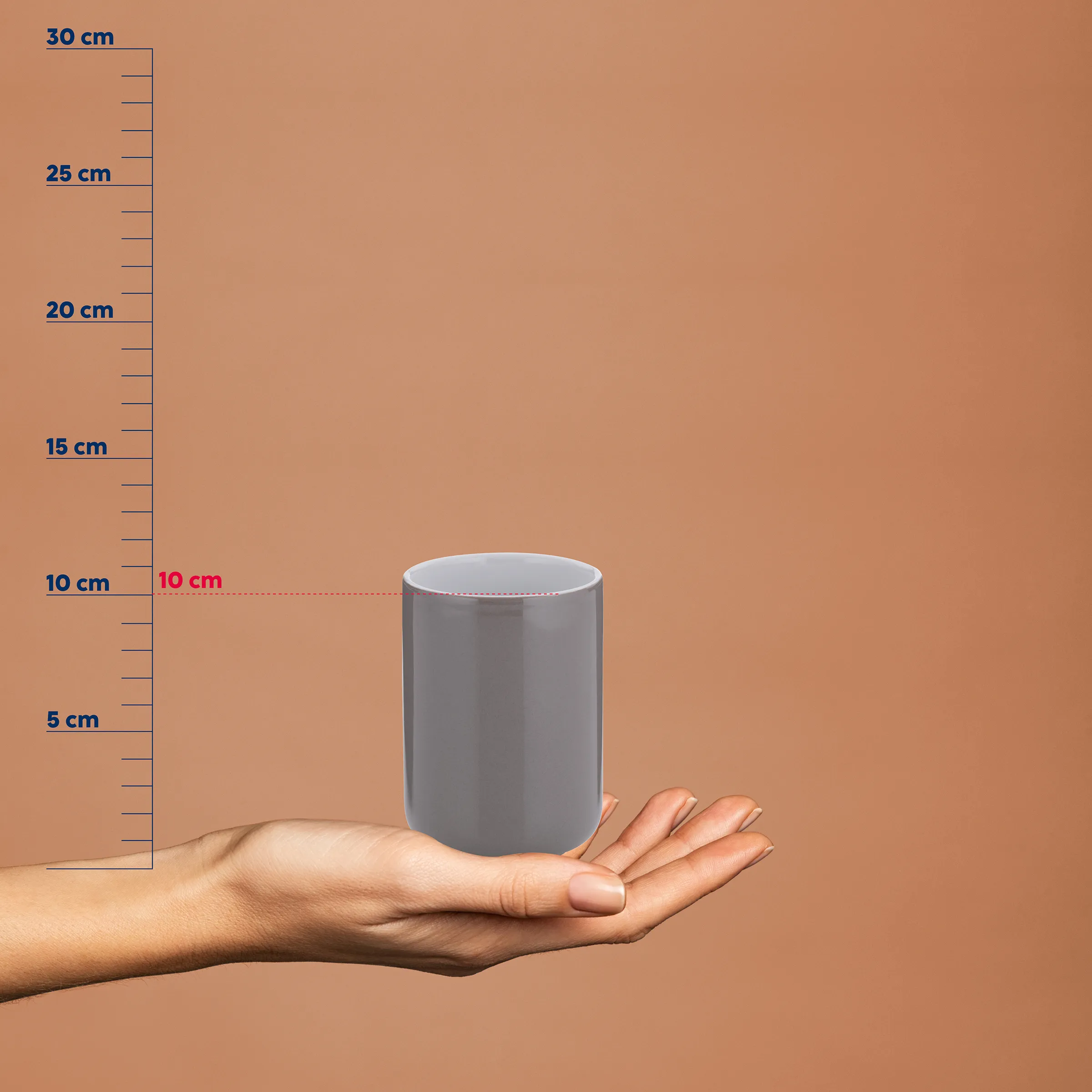 Grauer Zylinder mit weißem Rand auf einer Hand vor Messlatte, zeigt 10 cm Durchmesser und etwa 15 cm Höhe