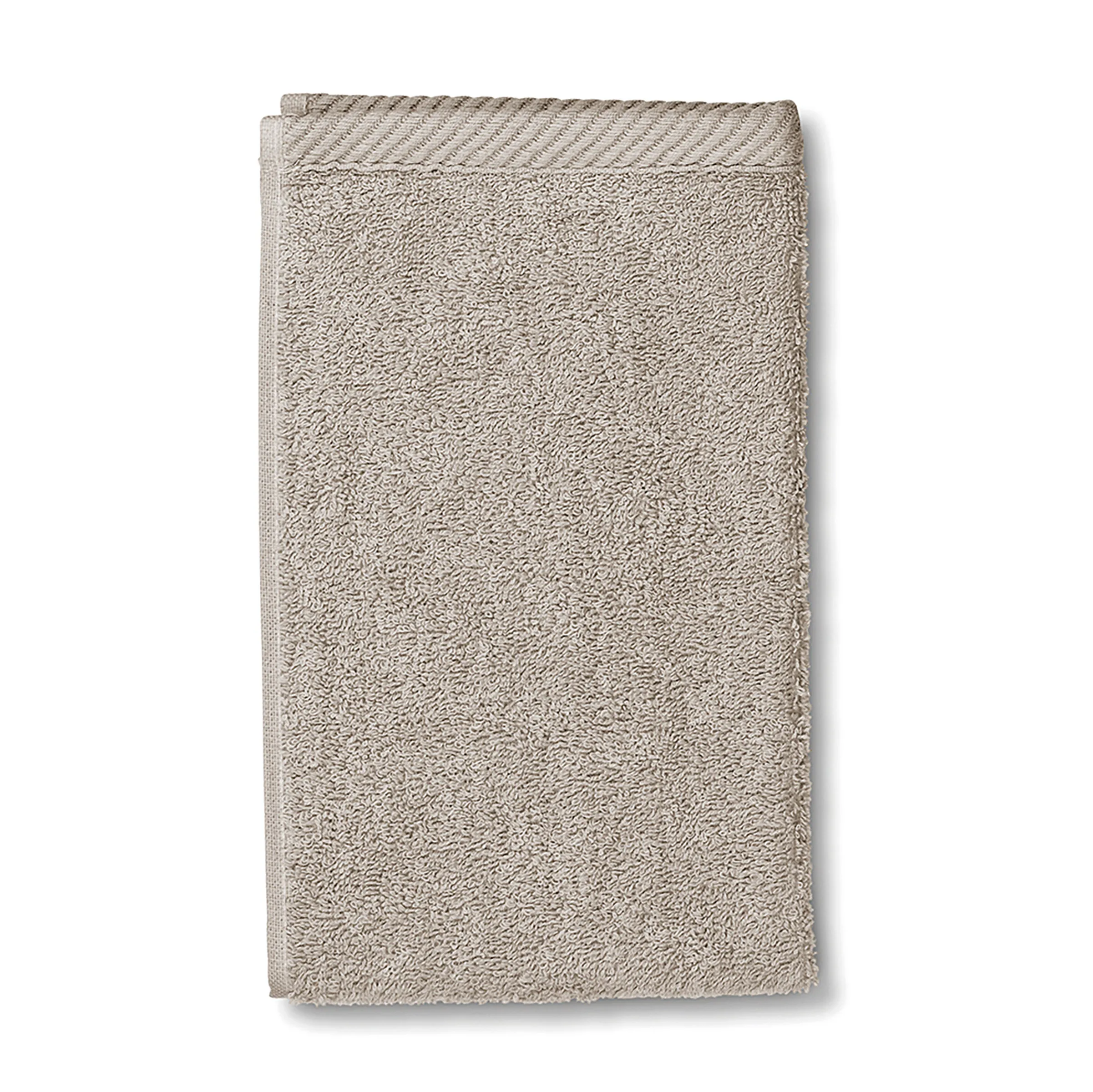 Beige Baumwoll-Handtuch strukturiert hochwertig Beige Handtuch aus Baumwolle mit strukturierter Oberfläche und gewebtem Rand, gefaltet auf weißem Hintergrund.