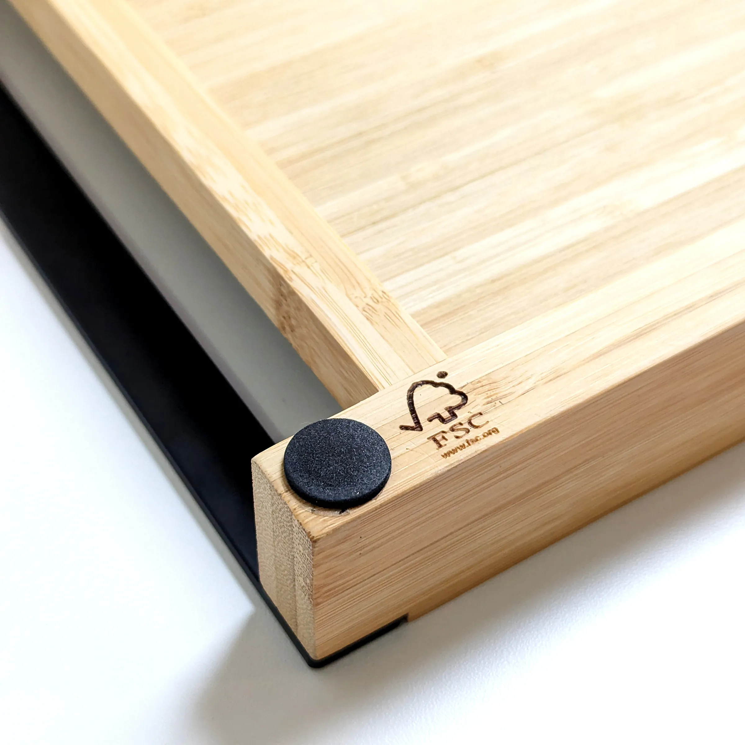 FSC Bambusrahmen mit Logo - Nachhaltige Holzrahmung Detailansicht Eckdetail eines FSC-zertifizierten Bambusrahmens mit Firmenlogo und schwarzem Gummipuffer auf weißem Untergrund