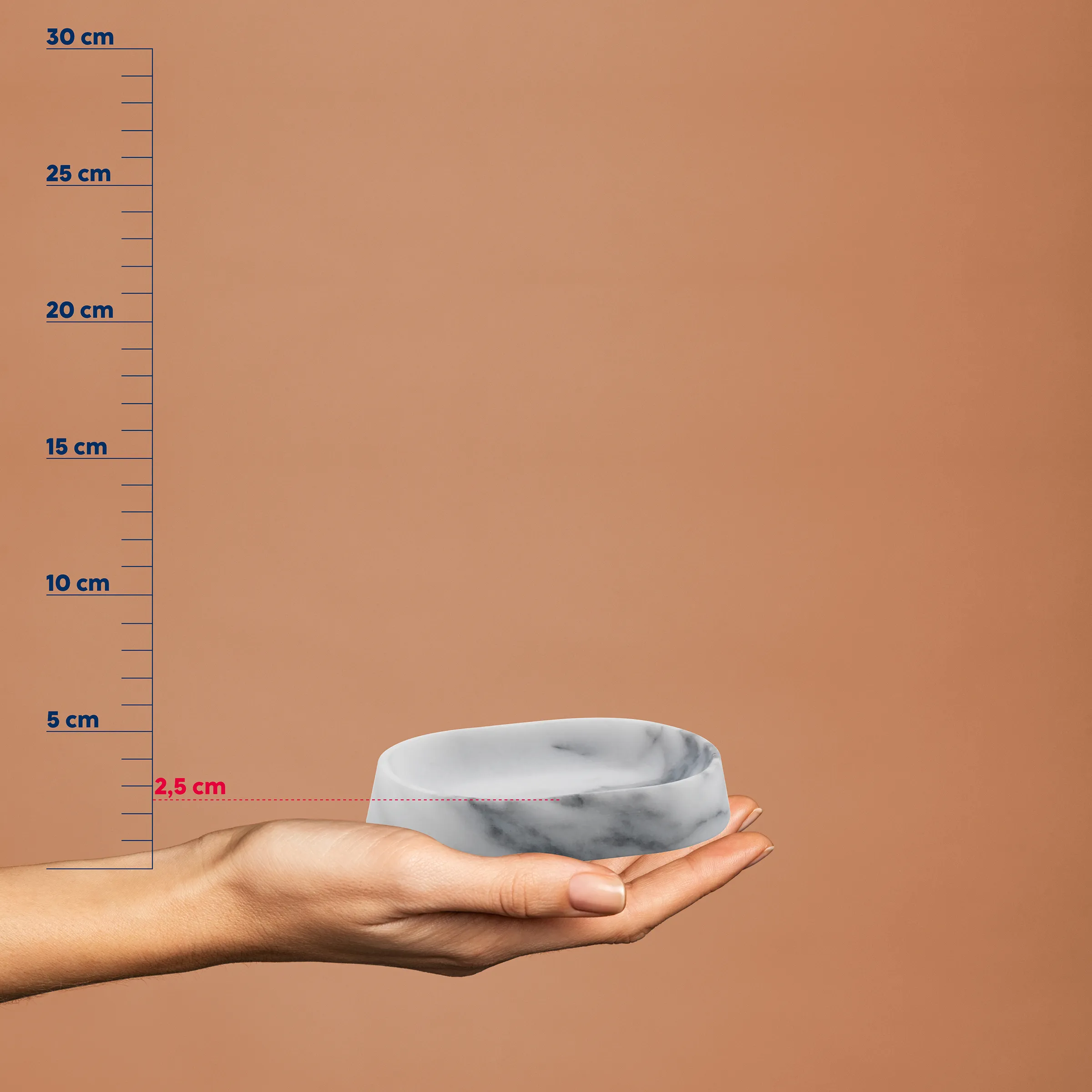 Hand hält weißen Napf mit Marmoroptik vor Maßstab, Höhe 2,5 cm