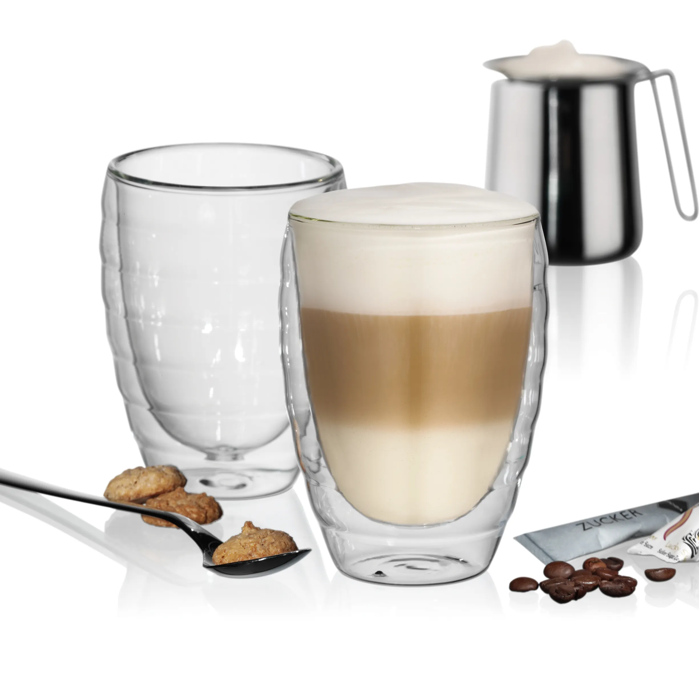Doppelwandige Kaffeegläser Set mit Cappuccino und Zubehör Doppelwandige Gläser mit Cappuccino, Milchkanne, leeren Glas, Keksen und Kaffeebohnen auf weißem Hintergrund
