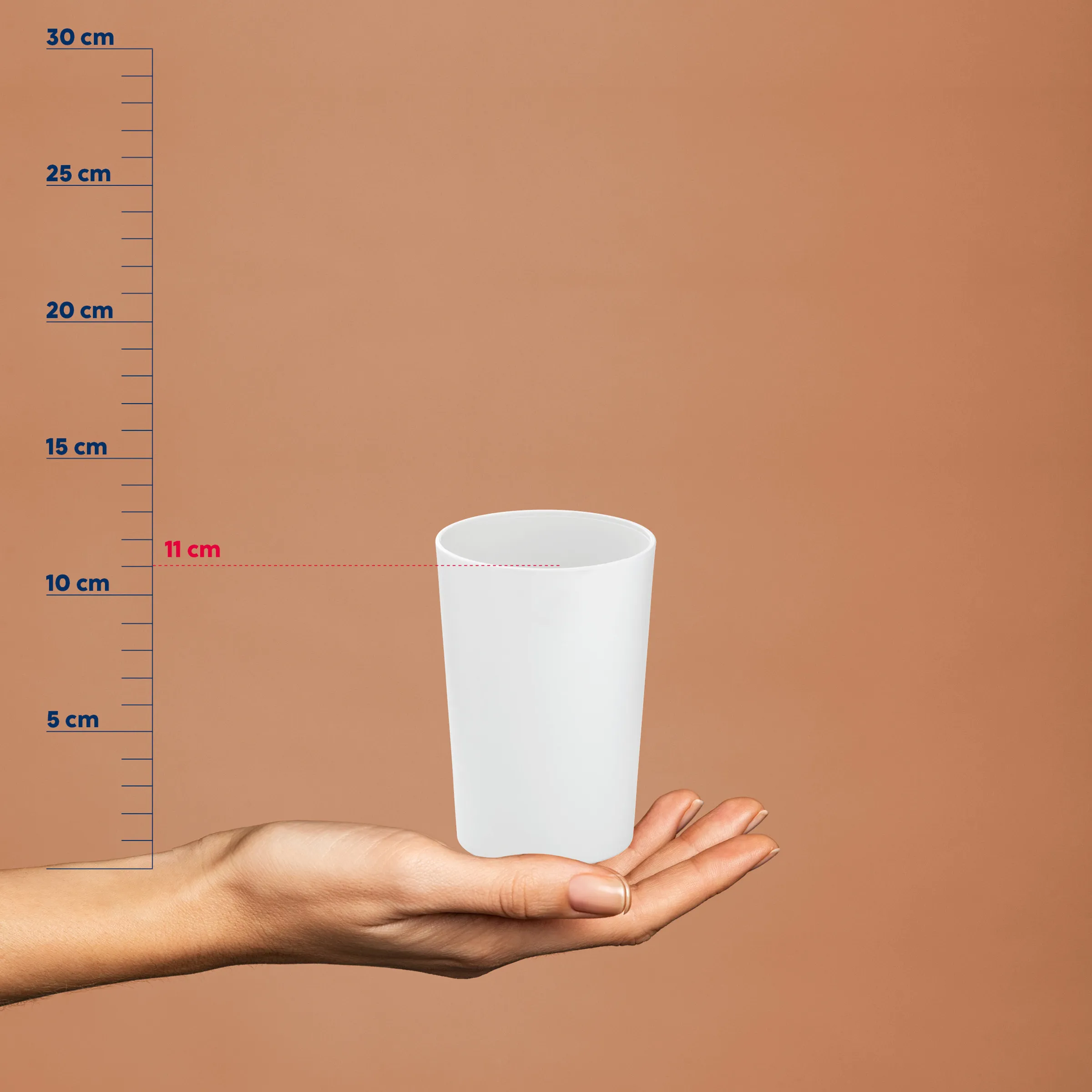 Weiße Kunststoffbecher mit 11 cm Höhe in einer Hand vor einer Messskala, die bis 30 cm reicht.