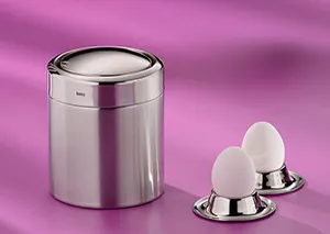 Eierbecher Edelstahl Set - Premium Eierbecher mit Eiern Edelstahl-Eierbecher mit zwei weißen Eiern auf silbernen Eierbechern vor rosa Hintergrund
