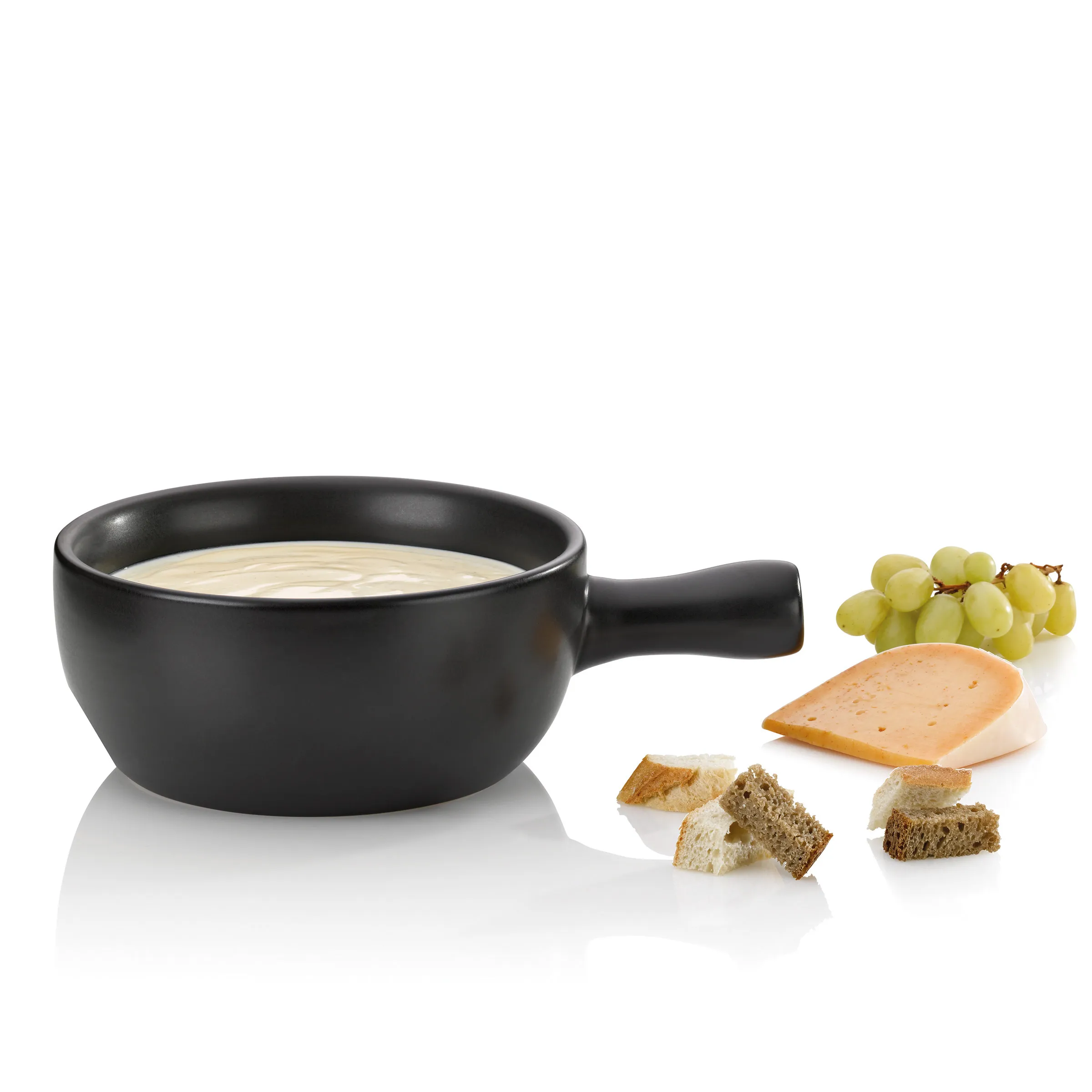 Fondue Set mit Käse - Klassisches Fondue Zubehör Schwarze Fondue-Schüssel mit Käse gefüllt, daneben Trauben, Käse und Brotwürfel zum Dippen