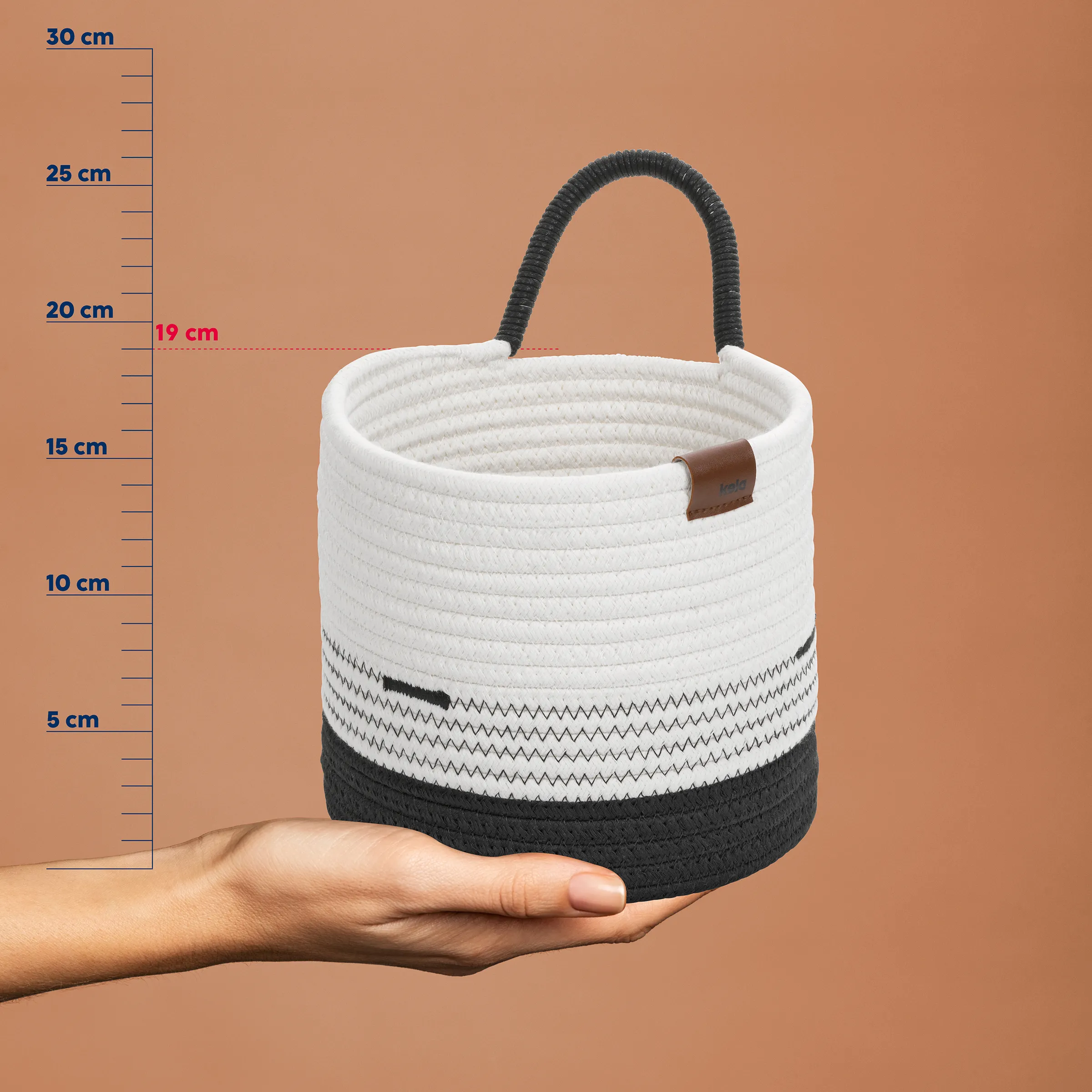 Aufbewahrungskorb Baumwolle grau-weiß mit Henkeln Weiß-graue Baumwoll-Aufbewahrungskorb mit schwarzen Henkeln, gemessen gegen Größenskala bis 30 cm