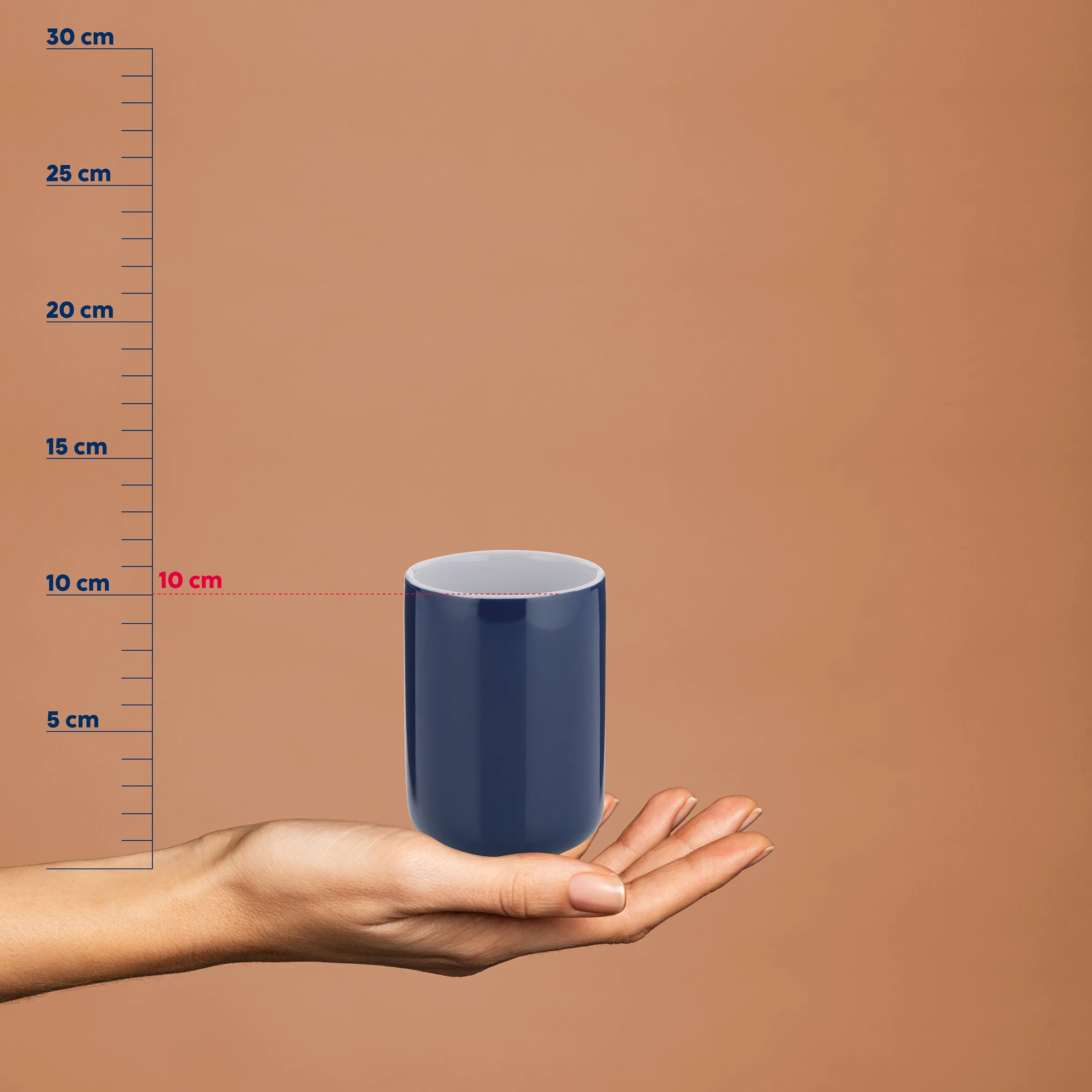 Dunkelblaue Keramiktasse mit 10 cm Durchmesser in einer Hand vor Größenvergleichsskala bis 30 cm