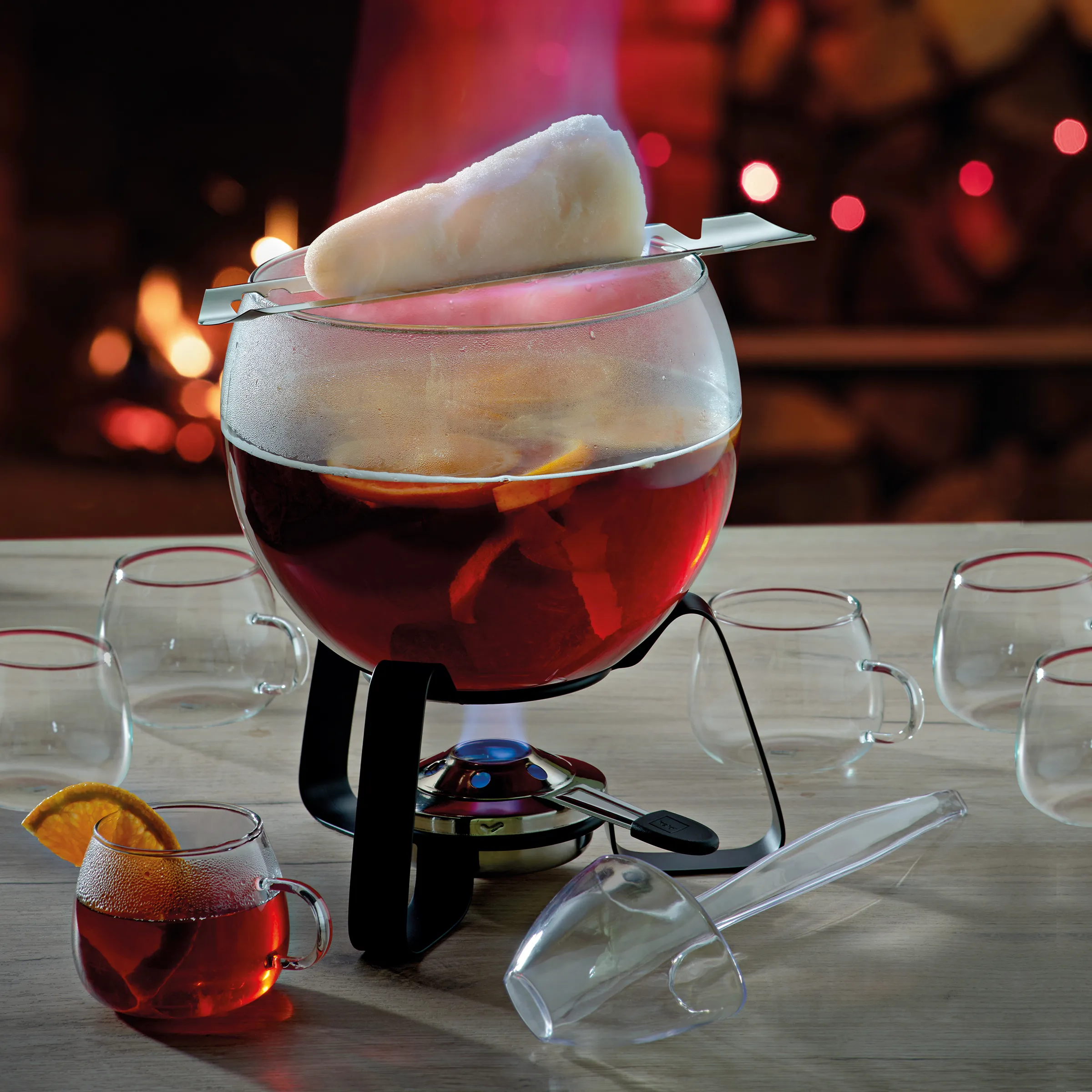 Fondue Set - Klassisches Käsefondue Zubehör Fondue-Set mit roter Flüssigkeit in großem Topf, weißem Schöpflöffel und leeren Gläsern auf Holztisch mit Bokeh-Hintergrund