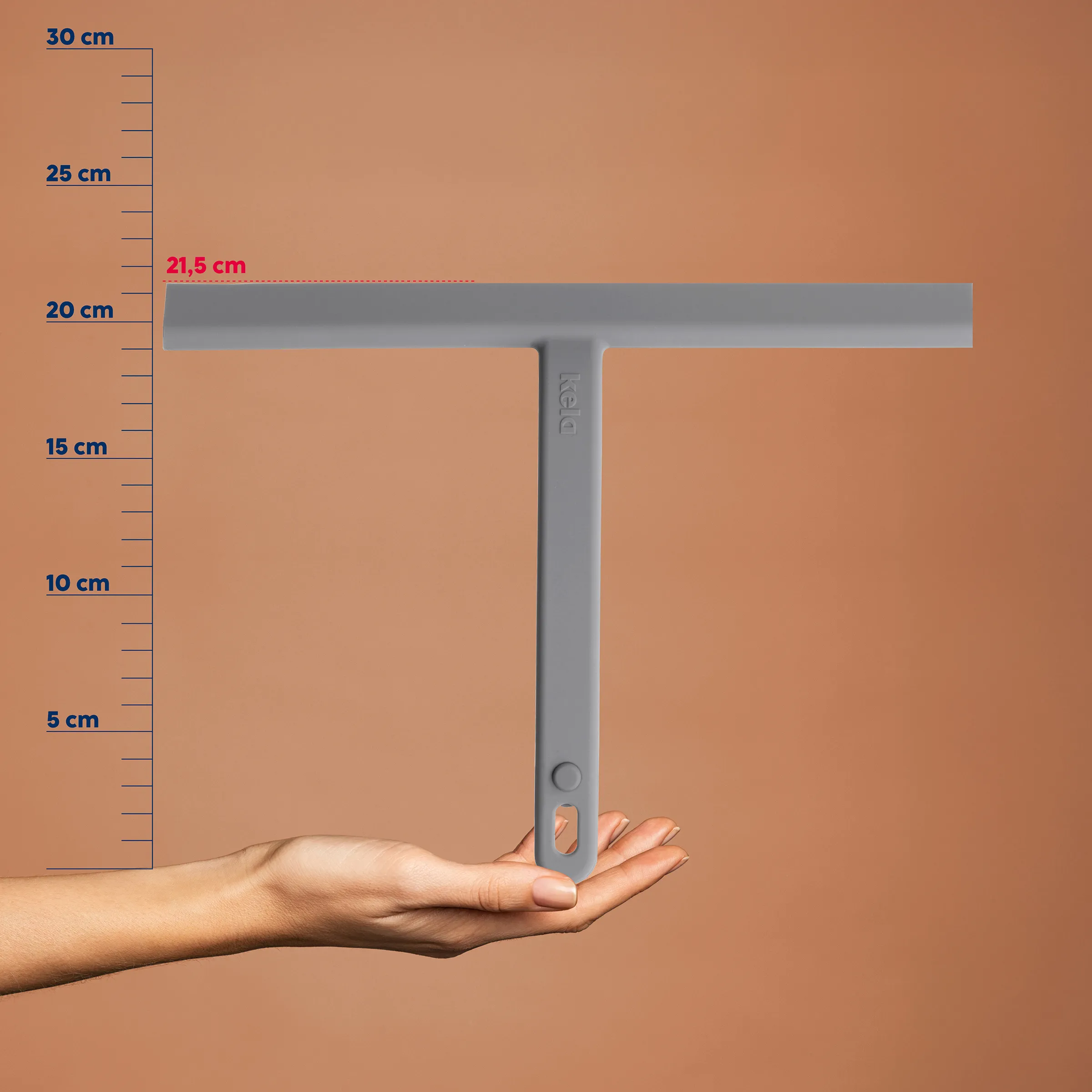 T-förmige Rakel 21,5 cm - Präzisionswerkzeug für Handwerk Hand hält graue T-förmige Rakel vor Messskala, Breite 21,5 cm markiert