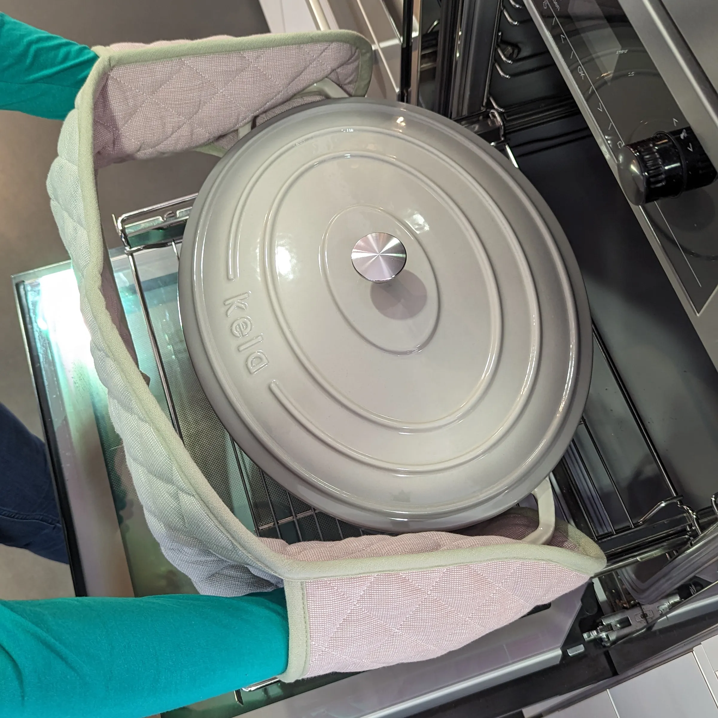Kochtopf mit Deckel aus dem Backofen holen - Ofenhandschuhe Küche Topf mit Deckel wird mit Ofenhandschuhen aus dem Backofen genommen