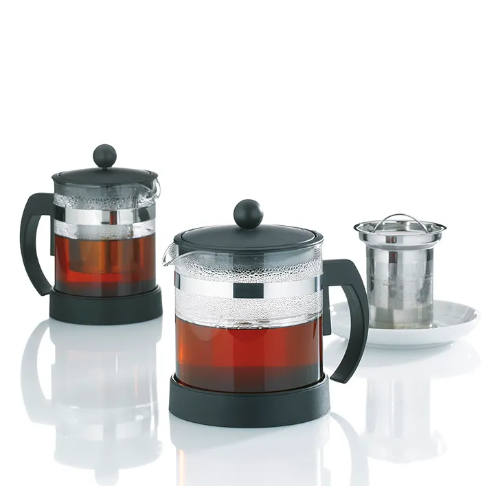 Teebereiter Set mit Glaskannen und Teesieb - Teekannen mit Filter Zwei Glaskannen mit Teebereiter und schwarzem Tee, daneben eine kleine Tasse mit Teesieb und Untertasse
