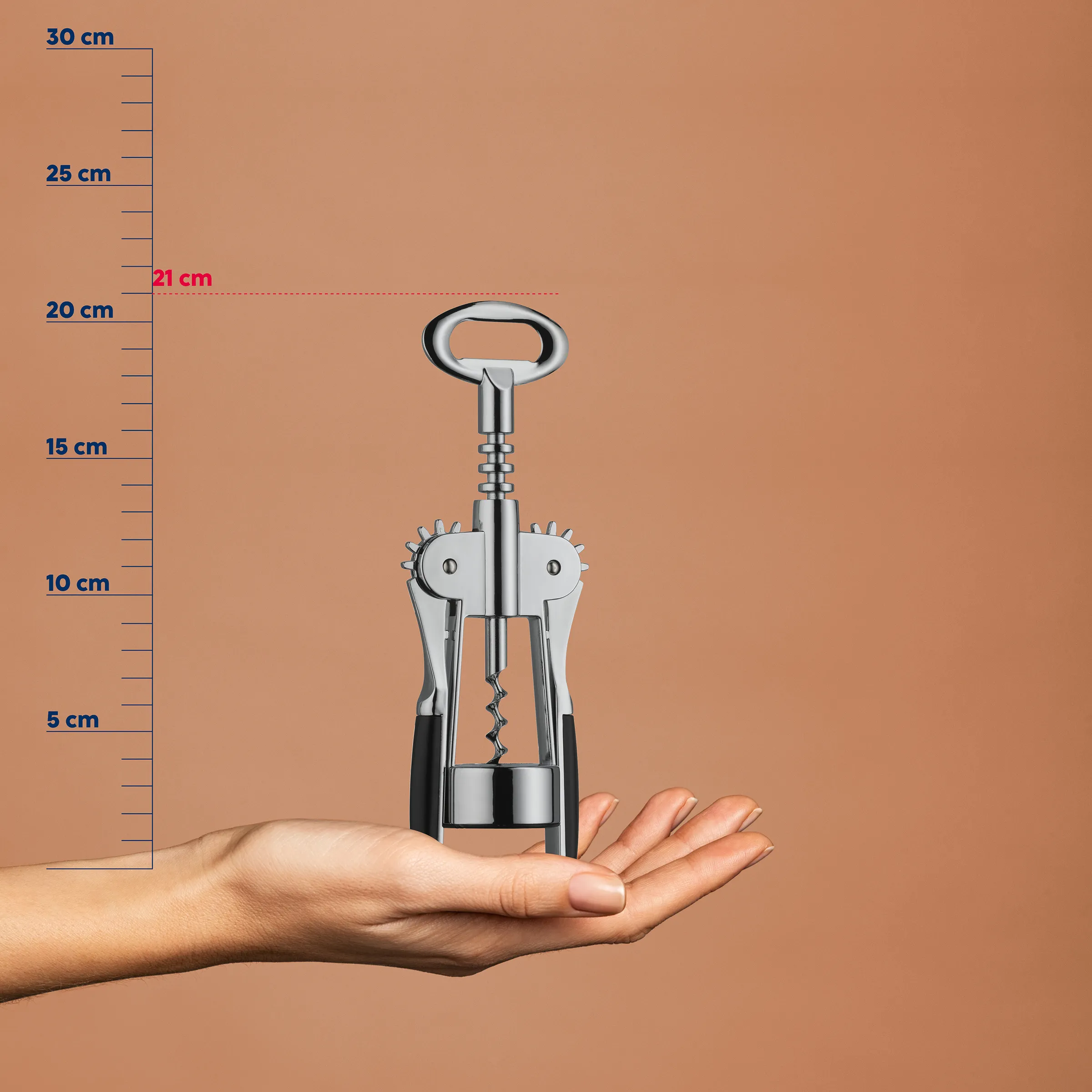 Korkenzieher mit Flügelgriff auf offener Hand vor Maßstab, Höhe ca. 21 cm