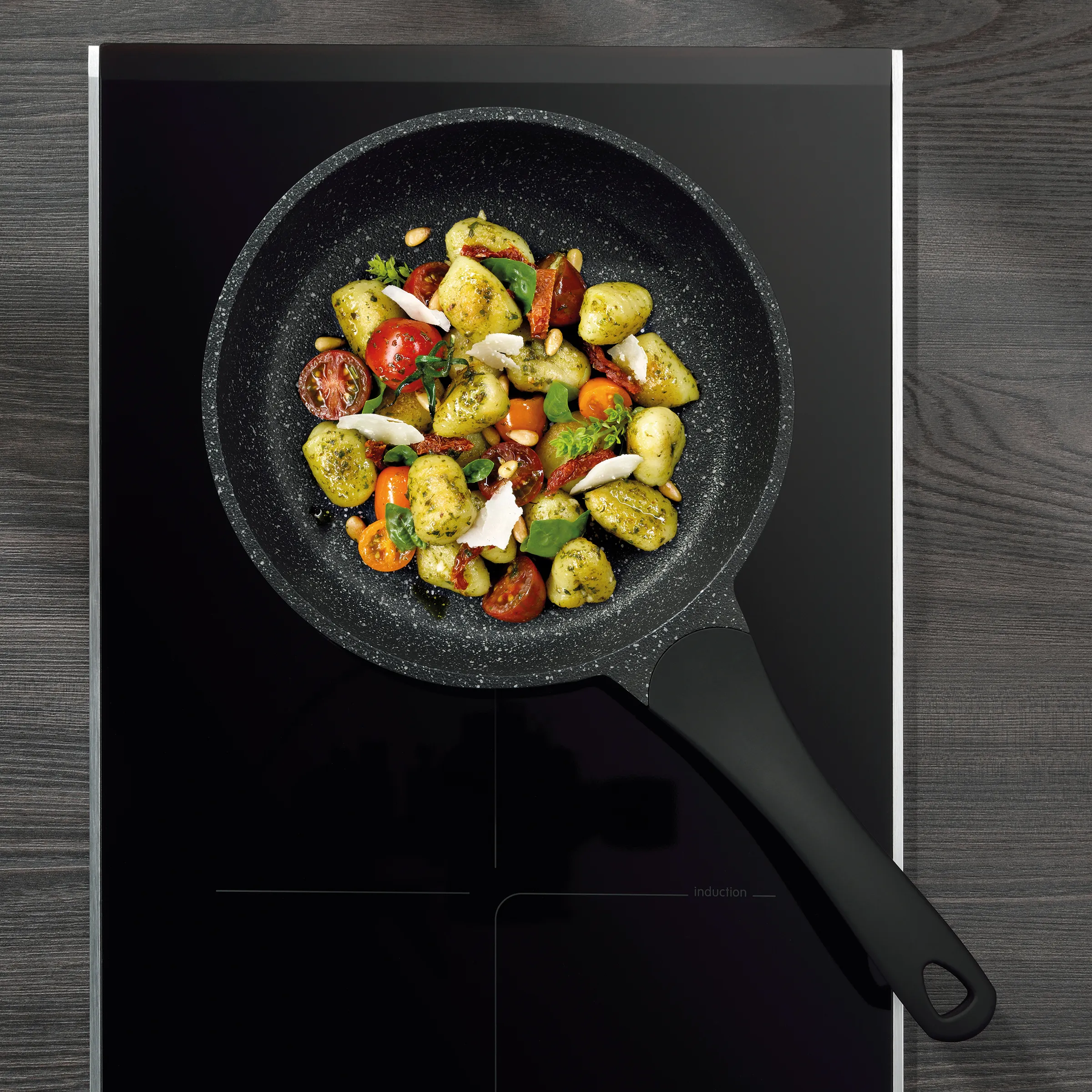 Gemüse Pfanne mit Kartoffeln und Mozzarella - Induktion Kochgeschirr Schwarze Pfanne mit sautiertem Gemüse - Kartoffeln, Tomaten, Paprika, Basilikum und Mozzarella auf Induktionsherd