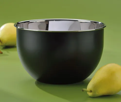 Schwarze Edelstahlschüssel mit Zitronen - Moderne Küchenschüssel Schwarze Edelstahlschüssel mit glänzendem Rand auf grünem Hintergrund neben gelben Zitronen