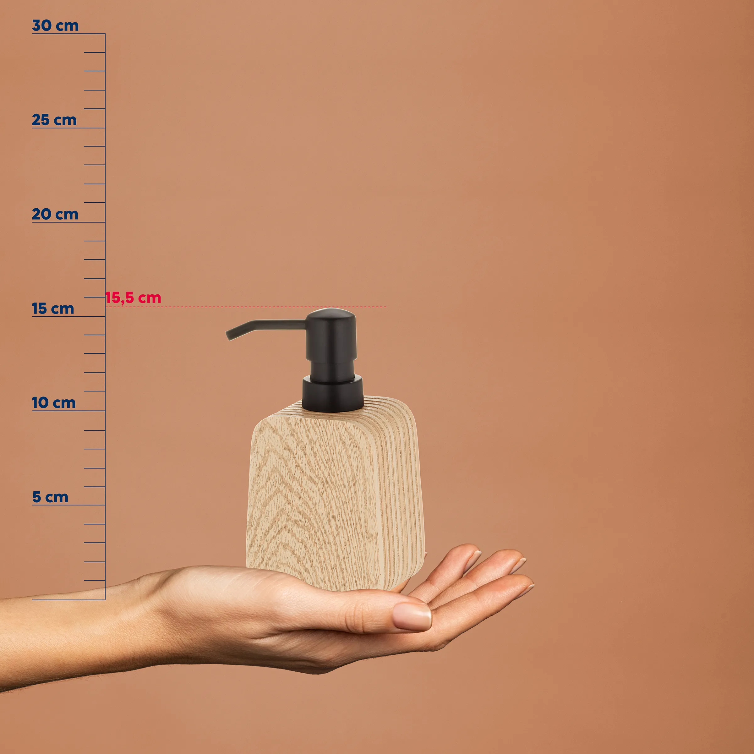 Seifenspender aus hellem Holz mit schwarzer Pumpe auf Hand, Größenangabe 15,5 cm, vor beigem Hintergrund