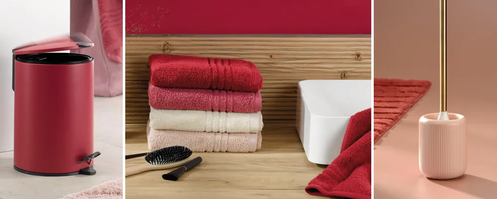 Badezimmer Accessoires Set rot und beige Badezimmer-Accessoires Set mit roten Handtüchern, rotem Mülleimer, weißer Zahnbürstenhalter und rosafarbenem Zahnbürstenbehälter auf Holzablage