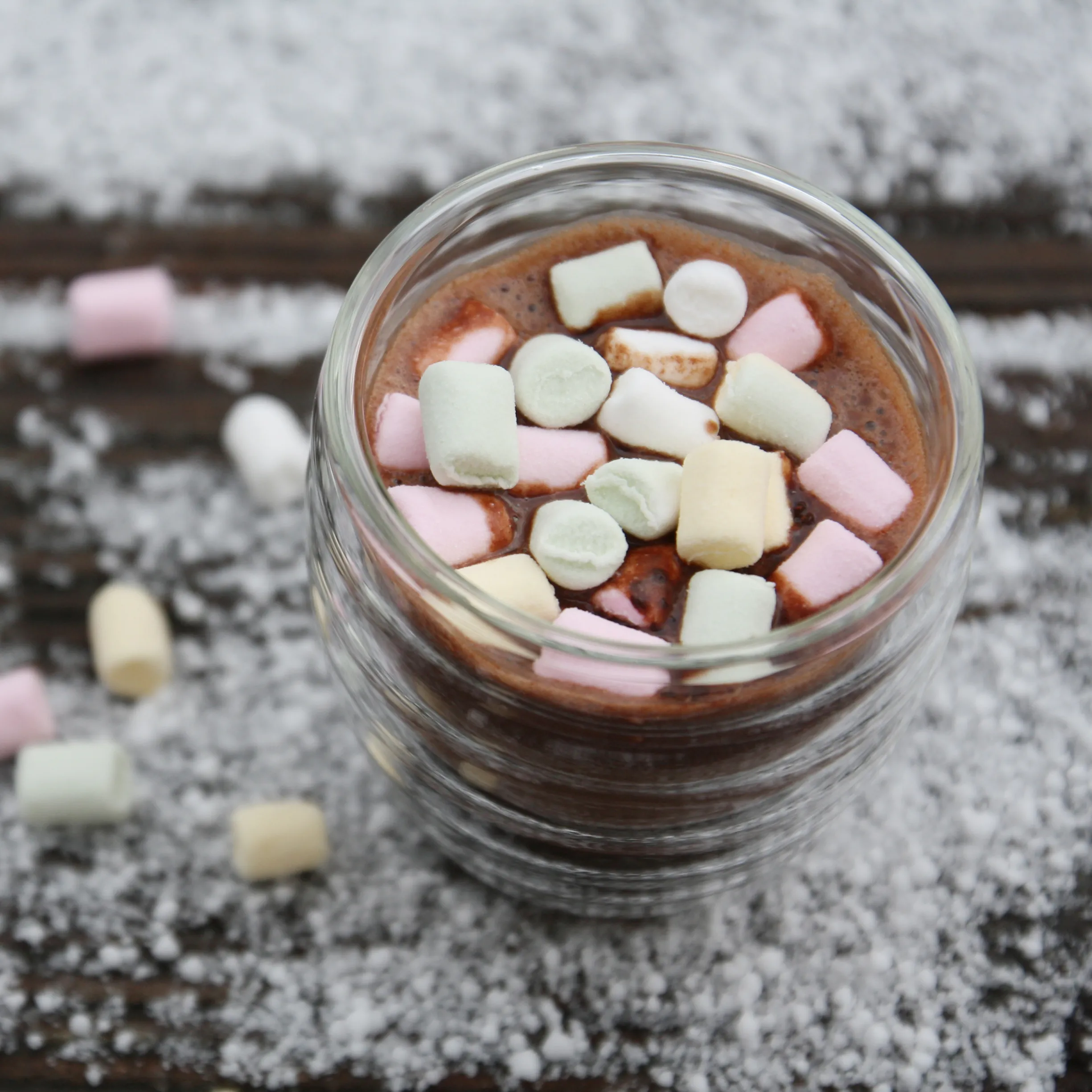 Schokoladencreme mit Marshmallows im Glas - Süßes Dessert Glas mit Schokoladencreme und bunten Mini-Marshmallows in Rosa, Weiß und Creme auf rustikalem Holztisch