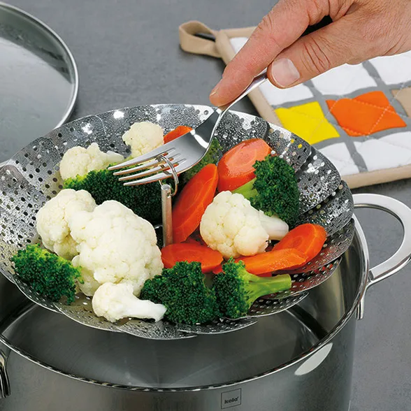 Dampfgarer Gemüse dämpfen - Edelstahl Siebeinsatz für gesundes Kochen Dampfgarer-Einsatz mit gedünstetem Gemüse: Blumenkohl, Brokkoli und Karotten über kochendem Topf