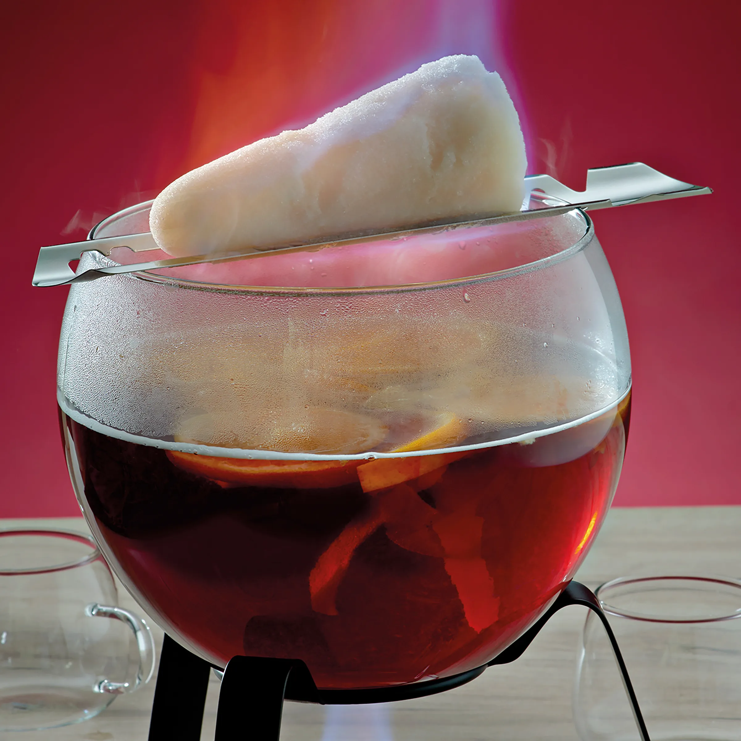Punsch Cocktail mit Schaumtopping - Erfrischendes Getränk Roter Punsch oder Cocktail in Glasschale mit Eis, Fruchtscheiben und großem Schaumtopping auf silbernem Löffel vor pinkem Hintergrund