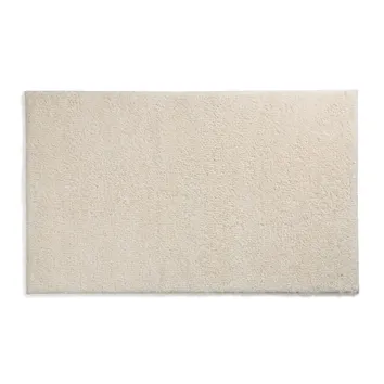 Beiger Teppich mit feiner Textur und rauen Fasern auf weißem Hintergrund.