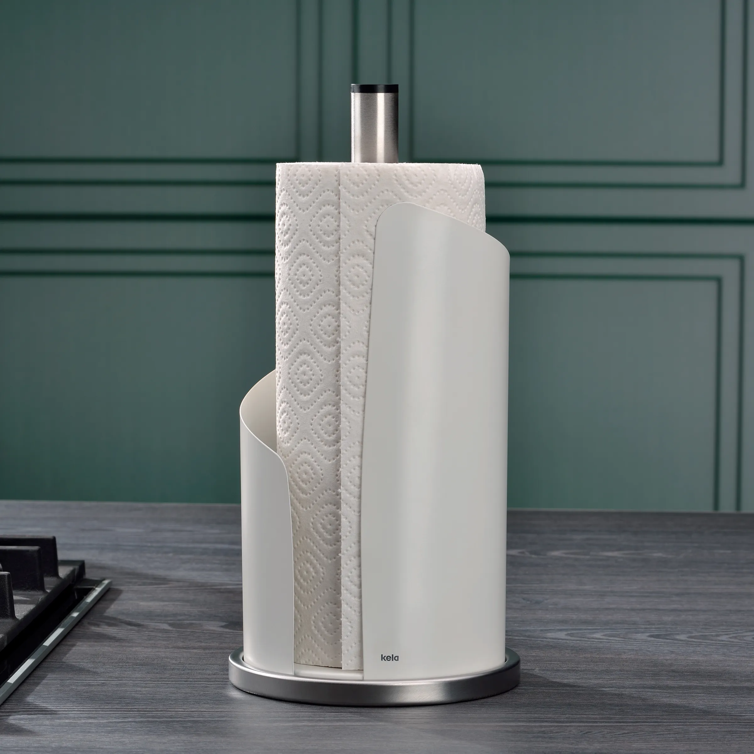 Küchenrollenhalter Edelstahl - Moderner Papierrollenhalter für die Küche Kela Küchenrollenhalter aus Edelstahl mit weißer Halterung und Küchenrolle vor grüner Wand