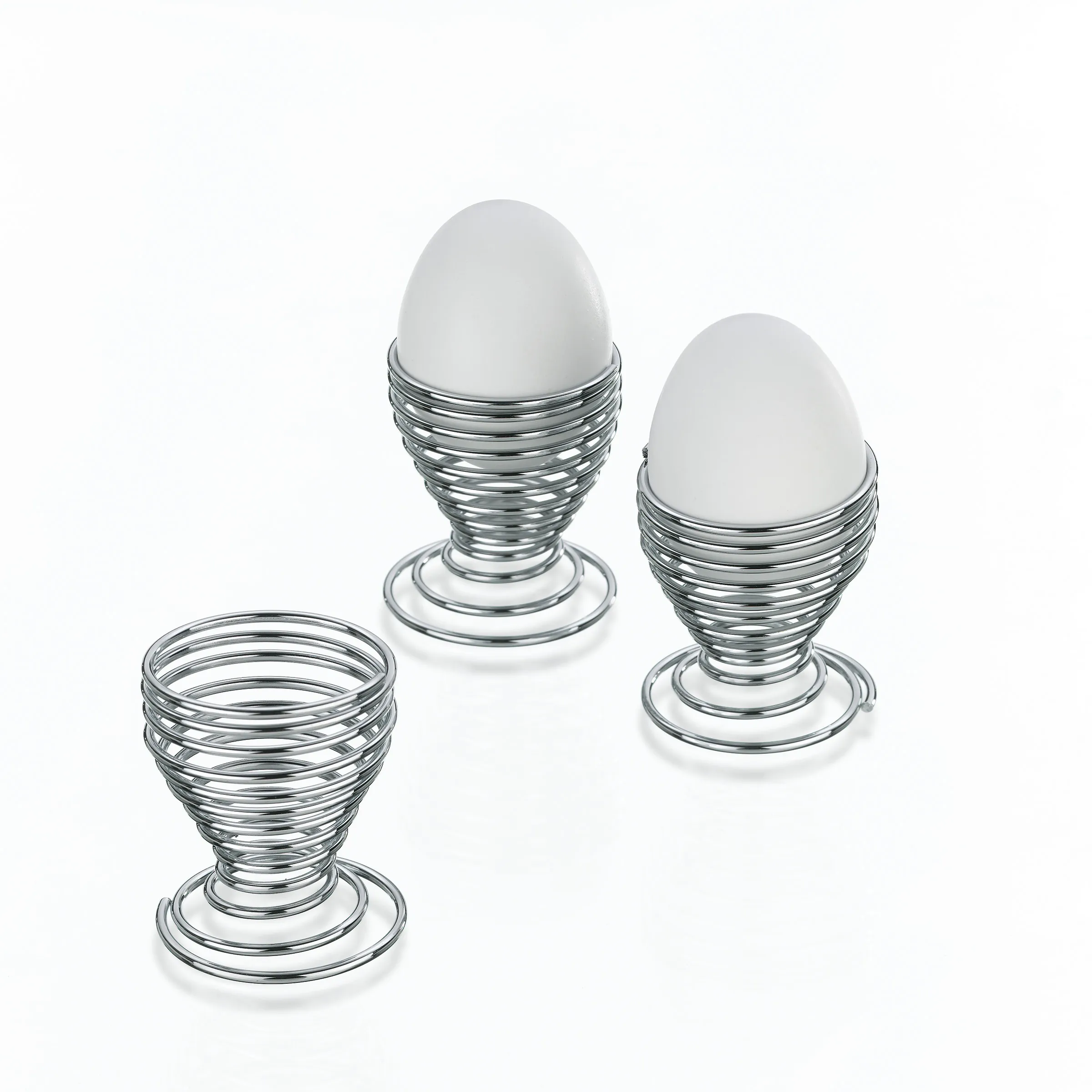 Glas Eierbecher Set - moderne Eierständer mit Spiraloptik Drei Eierbecher aus Glas mit spiralförmigem Design und weißen Eiern auf weißem Hintergrund.
