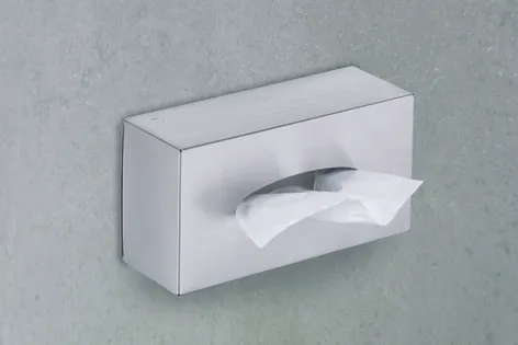 Papierhandtuch-Spender weiß - Wandmontage für Hygiene im Badezimmer Weißer Papierhandtuch-Spender aus Metall an grauer Wand montiert mit herausgezogenem Papiertuch