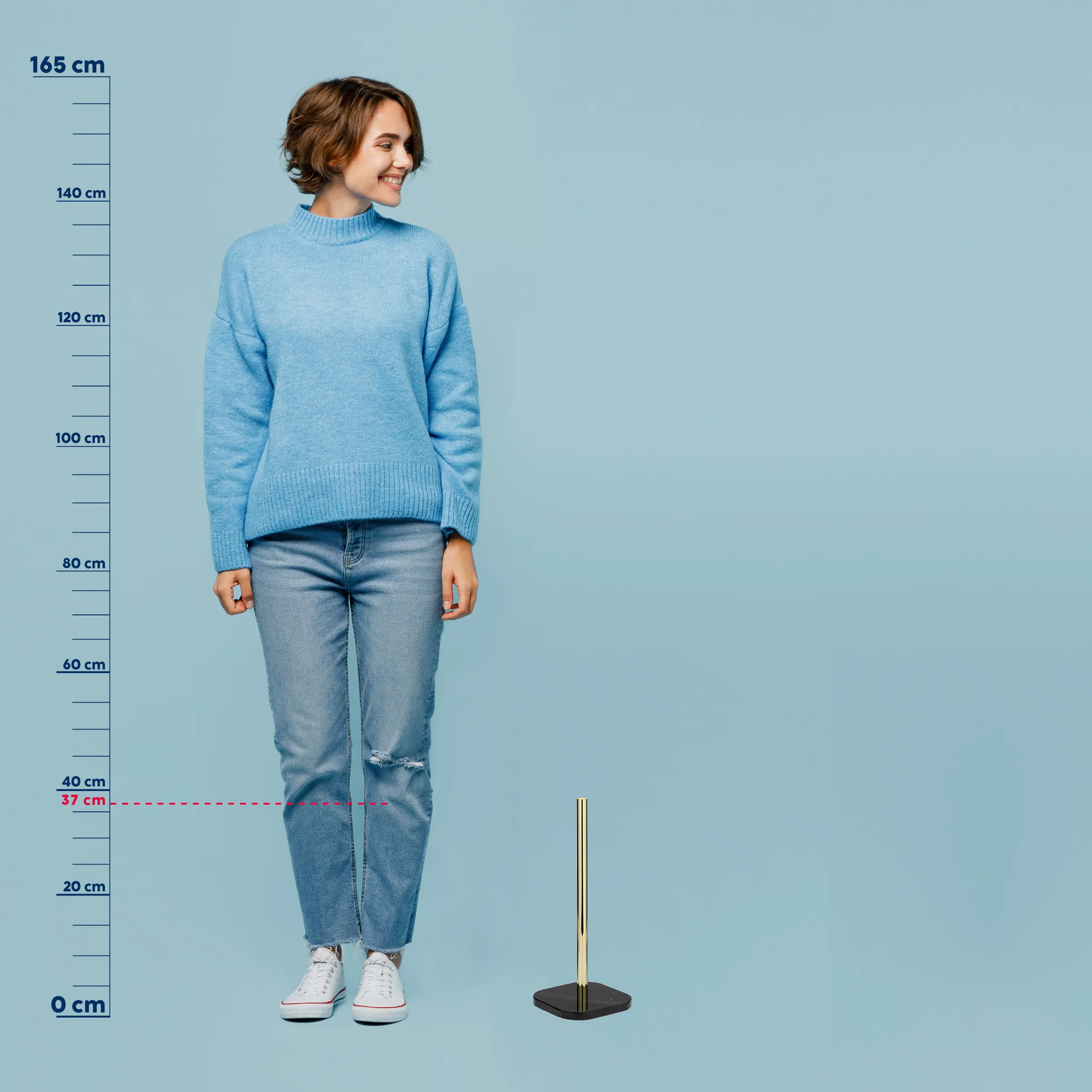 Größenreferenz Bekleidung - Frau mit Pullover und Kleiderständer Produktfoto Frau in blauem Strickpullover und Jeans vor Größentabelle, daneben moderner Kleiderständer mit Messingdetails